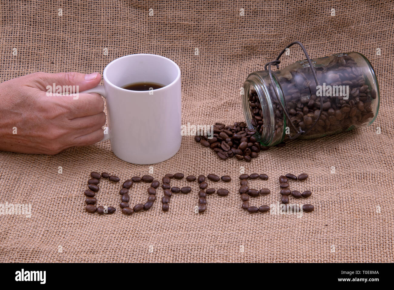 Kaffee Bohnen, Kaffee, Kaffeetasse, und ein Glas mit Bohnen, verschüttet Stockfoto