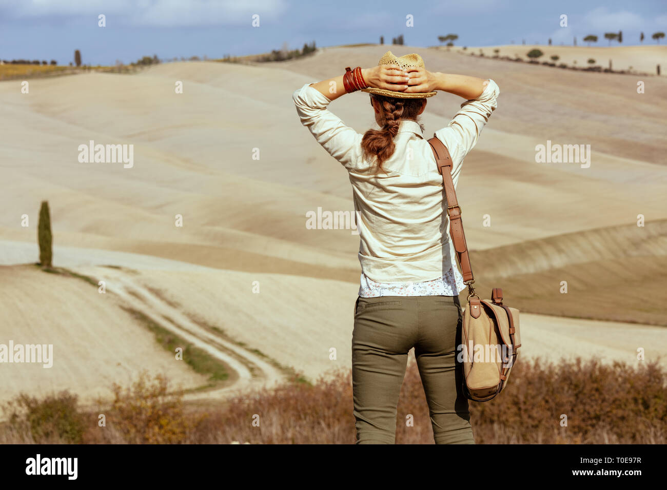 Hinter jungen Touristen Frau in Wanderausrüstung mit Tasche im Sommer Toskana Trail in die Ferne schauen gesehen. Stockfoto