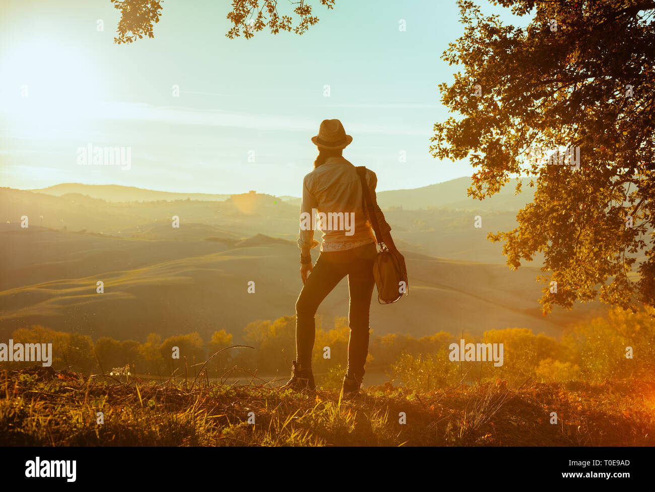 Volle Länge Portrait von Fit solo touristische Frau in Wanderausrüstung mit Tasche im Sommer in der Toskana Route in die Ferne schauen. Stockfoto