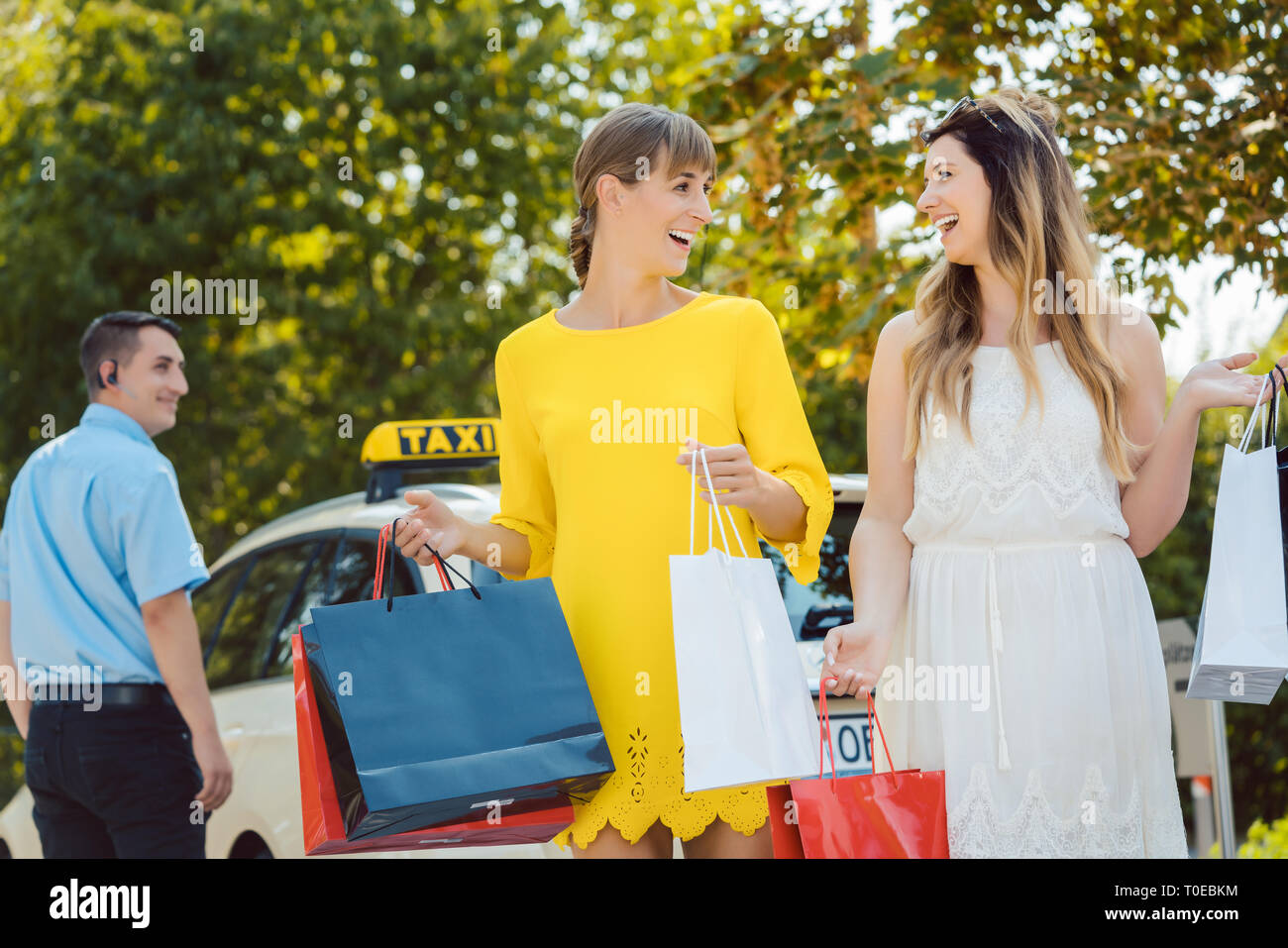 Zwei Frauen, die einander ihre Einkaufstaschen Stockfoto