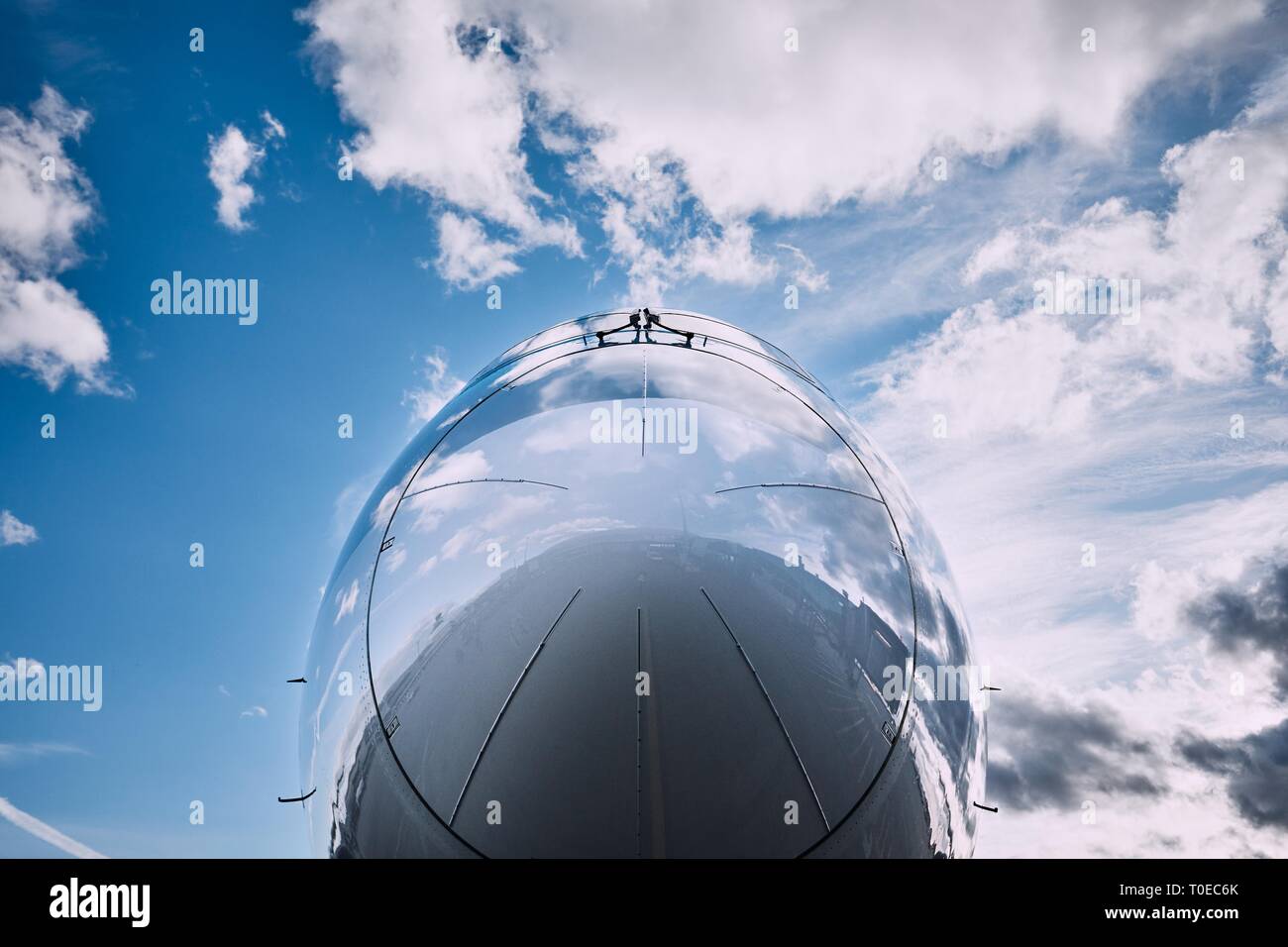 Reflexion von Wolken am Flugzeug. Nahaufnahme von Cockpit gegen den Himmel. Stockfoto