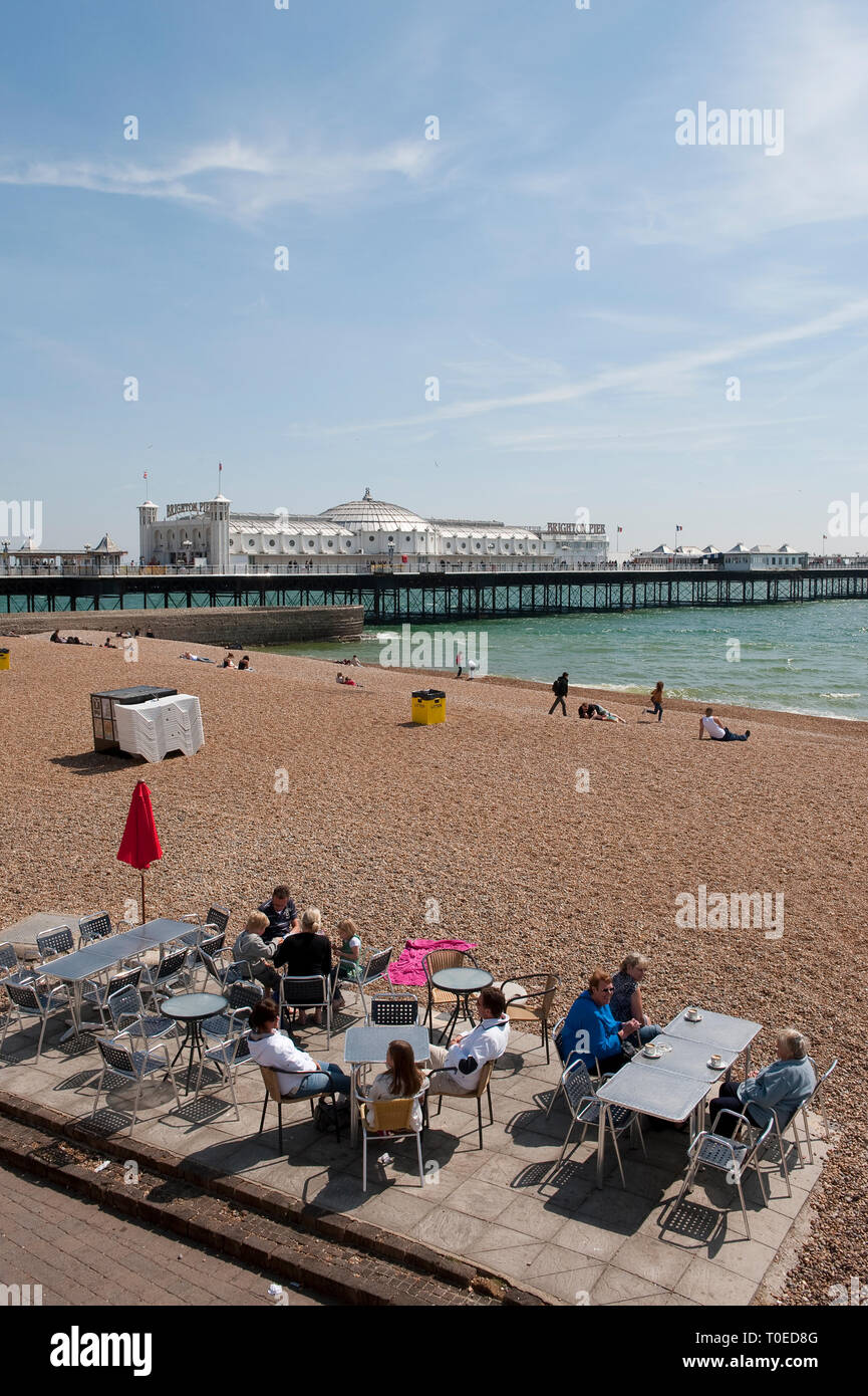 Urlauber genießen Sie Erfrischungen vor einem Cafe an der Strandpromenade von Brighton, Sussex, England sitzen. Stockfoto