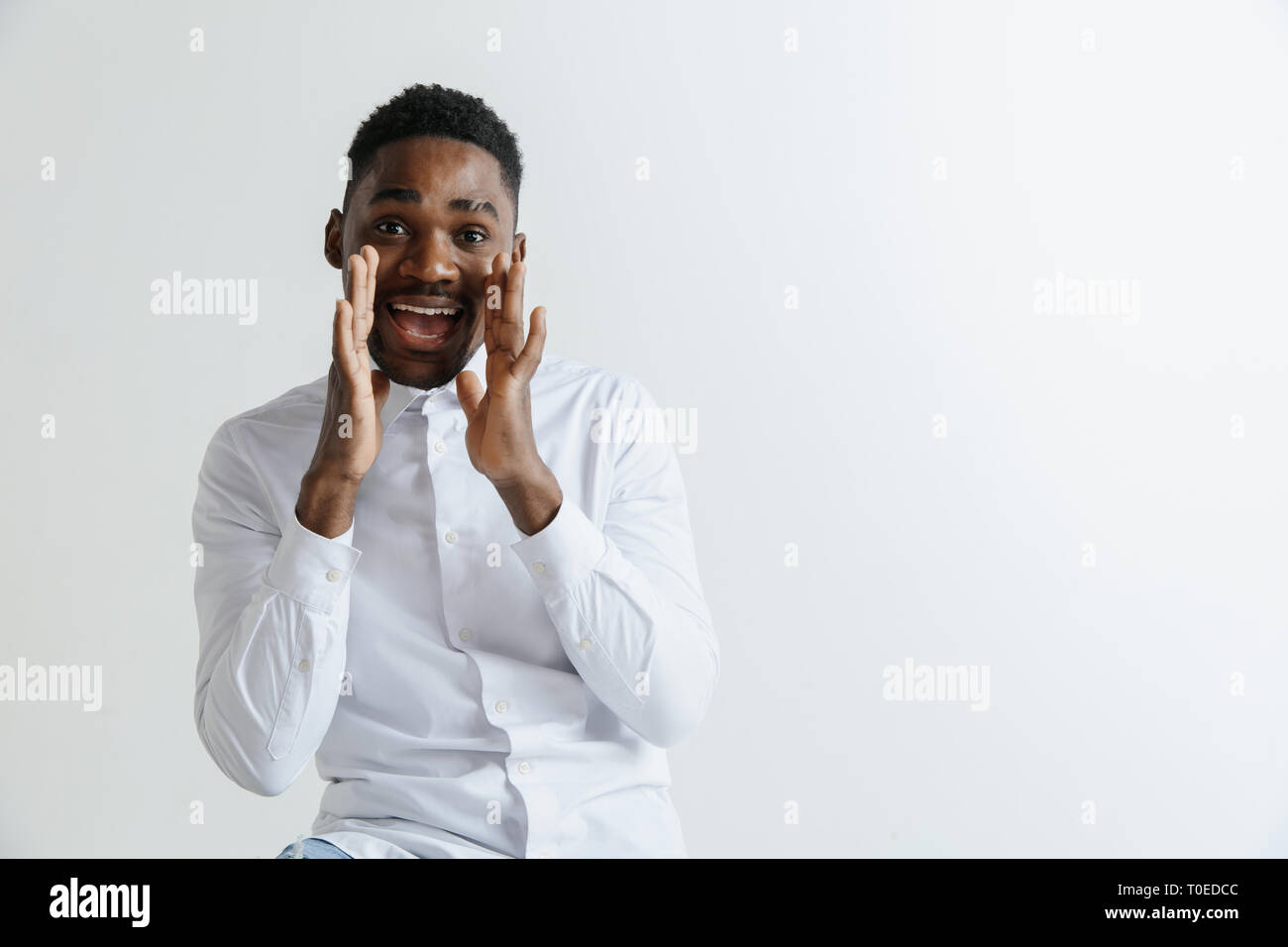 Wow. Attraktive männliche Hälfte - Länge vorne Portrait auf Grau studio Hintergrund. Jungen afro emotionale überrascht, bärtigen Mann mit offenen Mund. Menschliche Gefühle, Mimik Konzept. Stockfoto