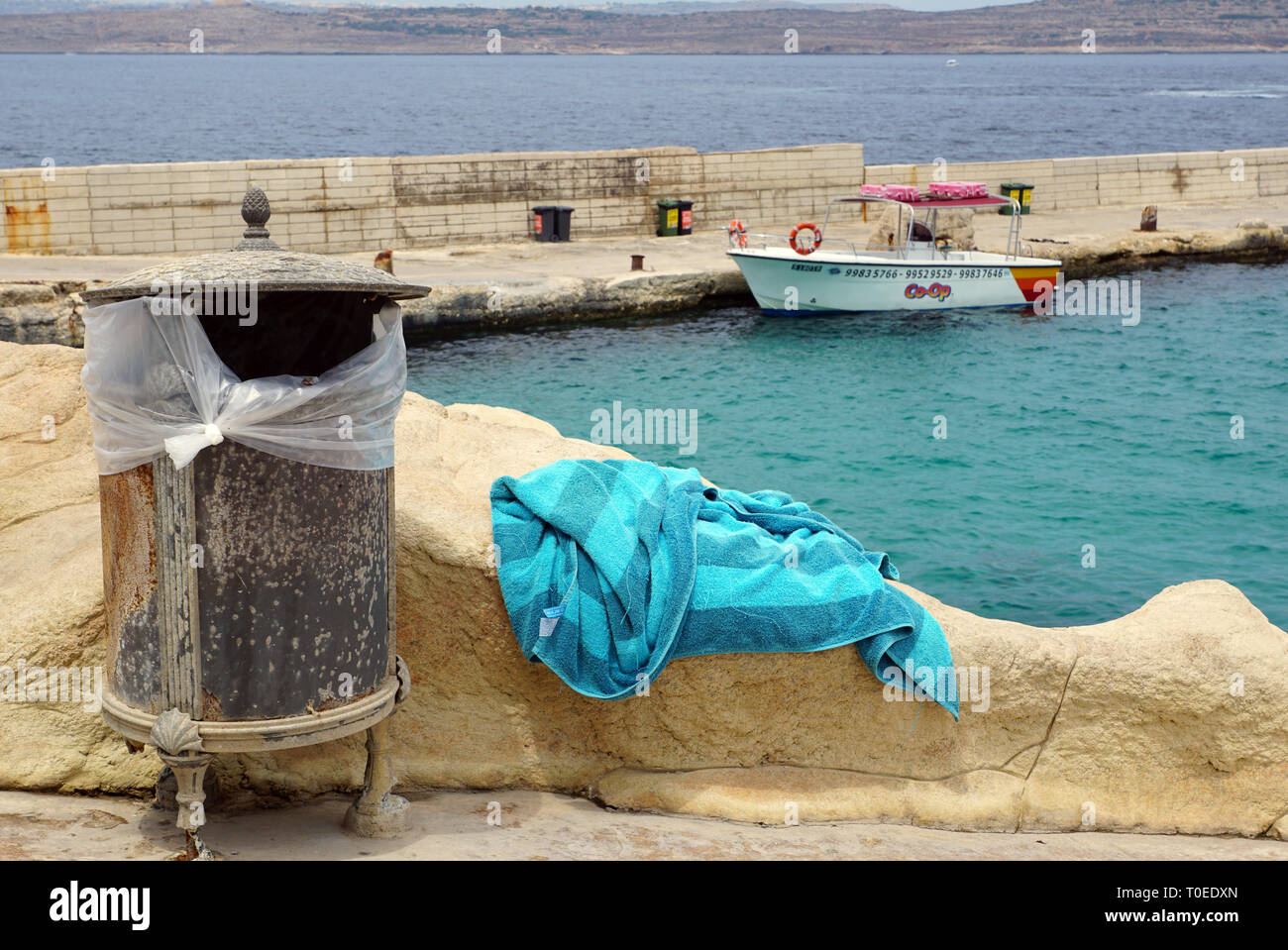 Strandtuch Neben dekorativen Mülleimer, Schiff und Meer im Hintergrund Stockfoto