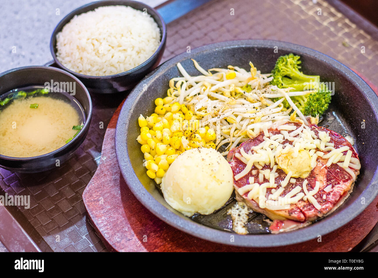 Sizzling Warmhalteplatte Ribeye Steak mit Mais, beansprout, Brokkoli, Reis, miso Suppe. Stockfoto