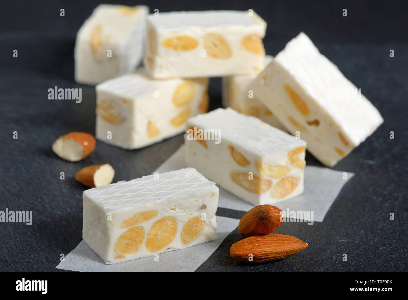 Weißer Nougat mit Mandeln auf schwarzen Ardesia Teller Stockfoto