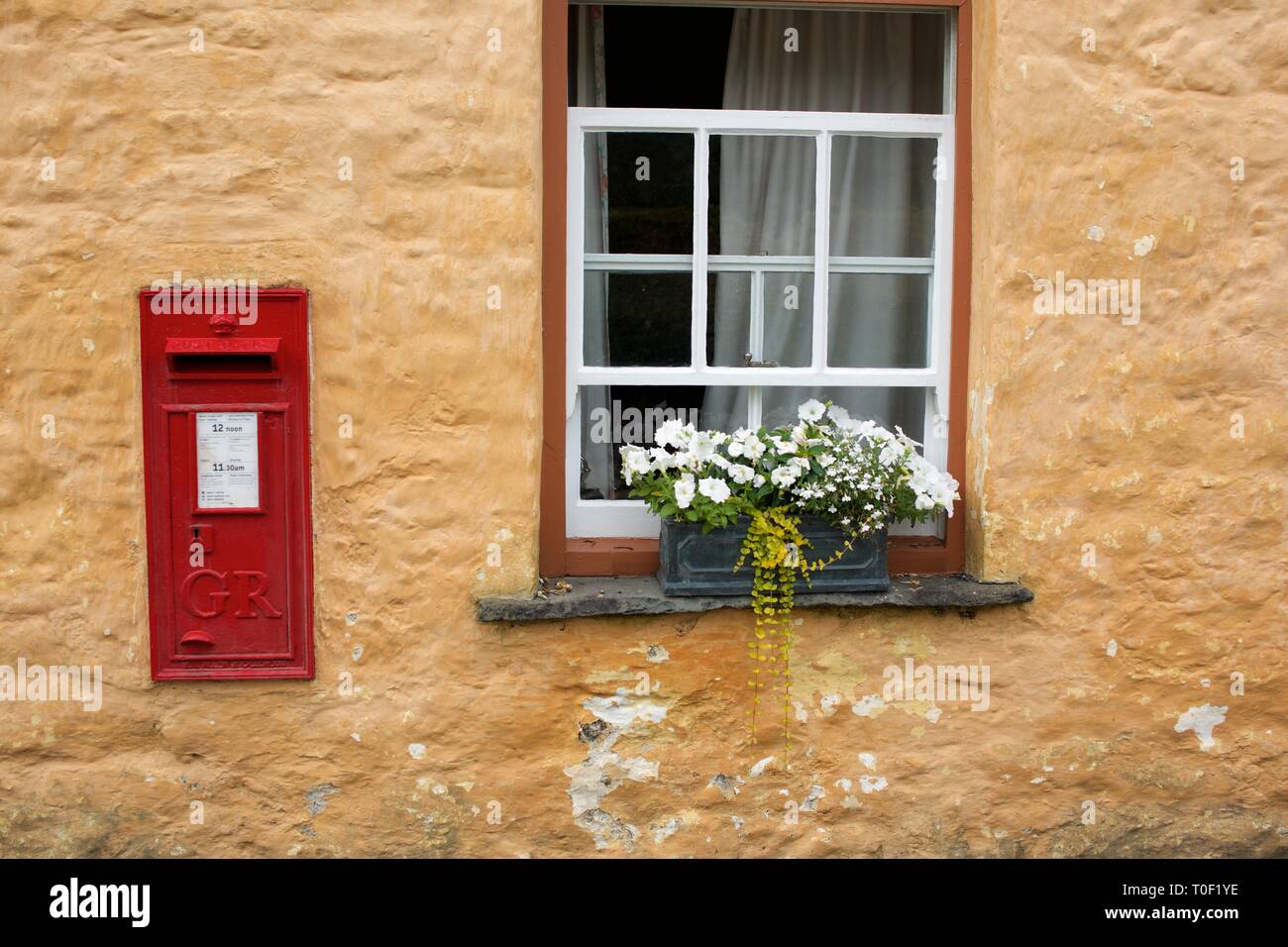 Traditionelle rote Post Box Set in ein Landhaus aus Stein Wand in einem Dorf in Wales Stockfoto