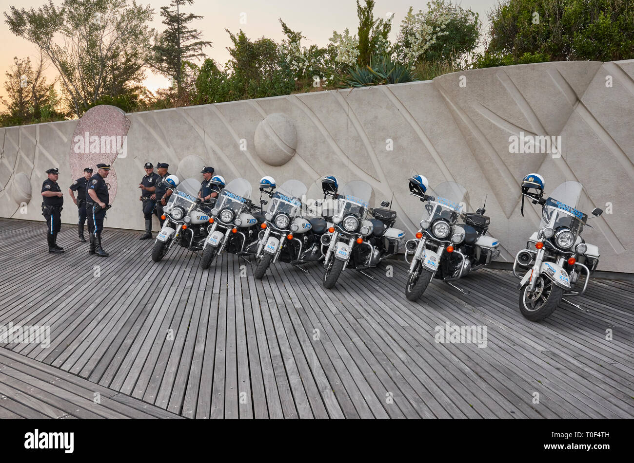 New York, USA - Juli 02, 2018: NYPD Highway Patrol Offiziere und Motorräder auf der Coney Island Beach Boardwalk bei Sonnenuntergang. Stockfoto