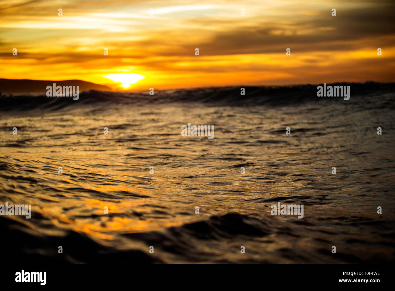 Wellen bei Sonnenuntergang. Stockfoto