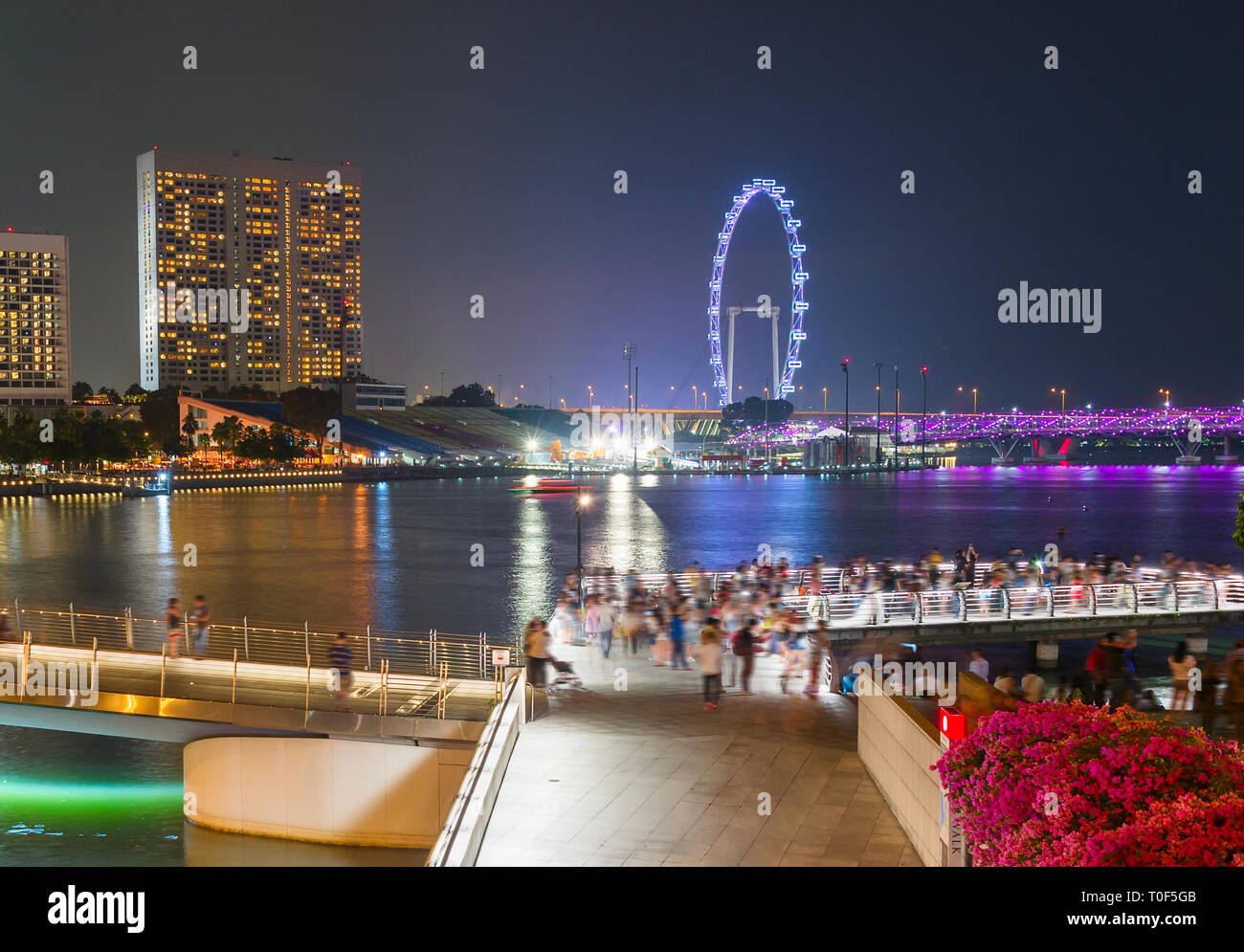 Touristen zu Fuß durch Singapur Promenade, beleuchtete Flyer Stockfoto