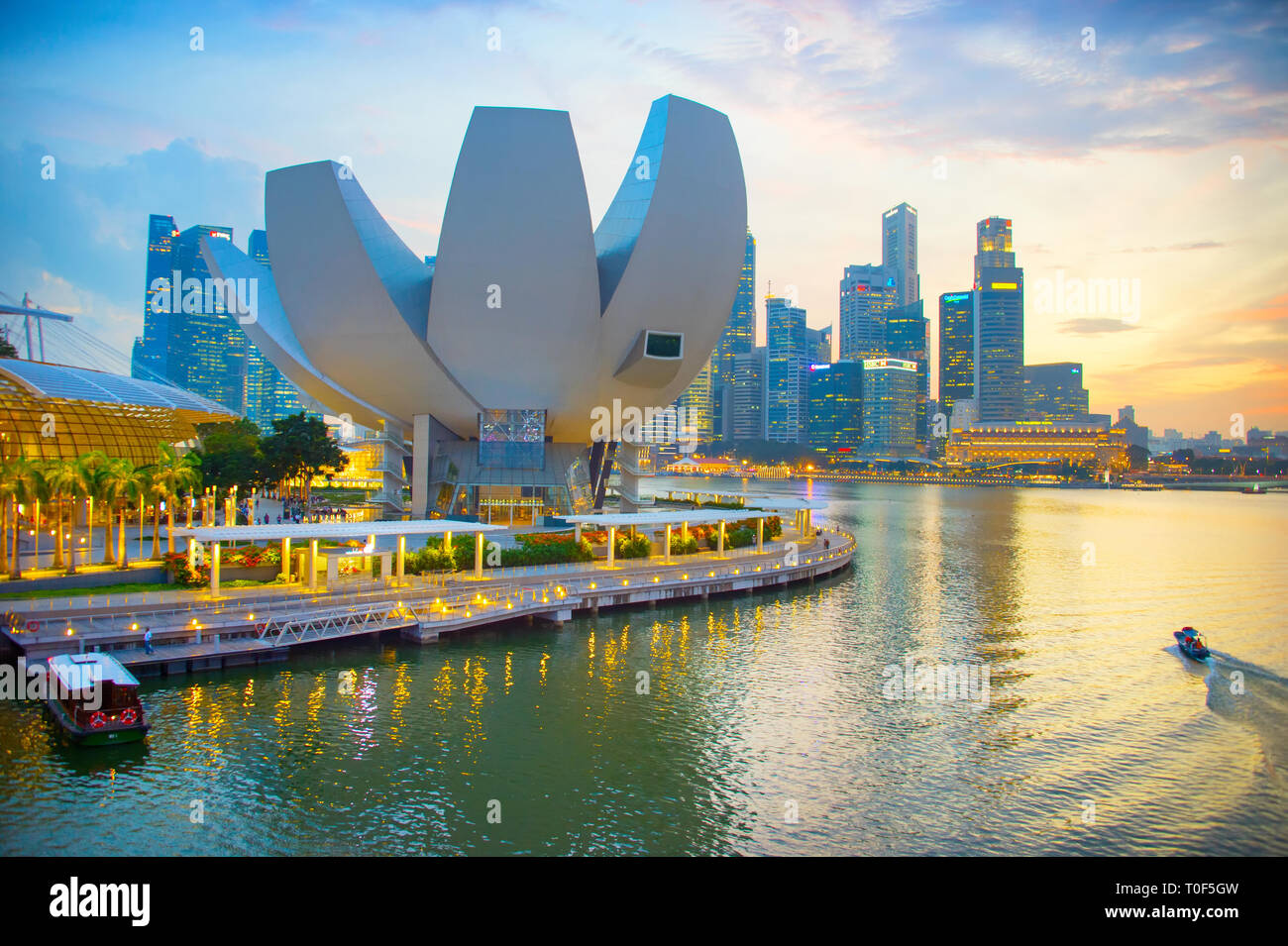 Singapur - Januar 3, 2017: Sonnenuntergang über beleuchtete Marina Bay Skyline mit ArtScience Museum lotus Gebäude der modernen Architektur im Vordergrund, Si Stockfoto