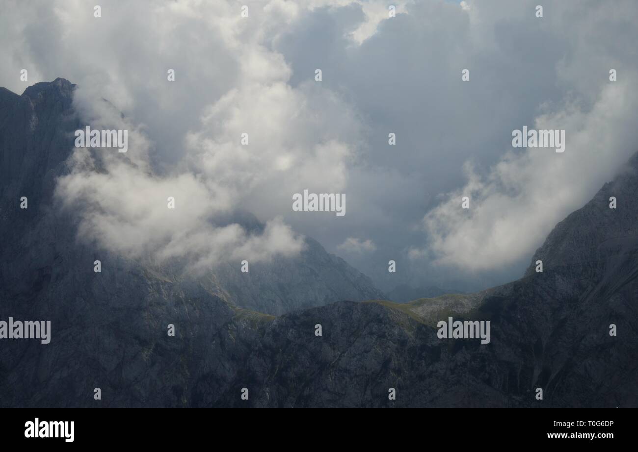 Sonnenstrahlen breking durch niedrige Wolken über Kamnik Sadddle in Kamnik Svinja Alpen, Slowenien Stockfoto