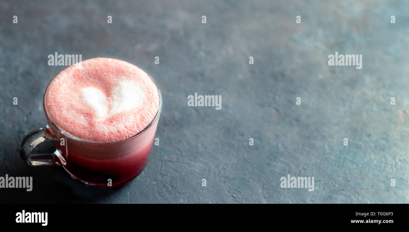 Trendgetränk: Pink Red velvet Latte. Rote Beete Cappuccino oder Latte in Glas Schale auf schwarzen Hintergrund. Kopieren Sie Platz für Text. Banner Stockfoto