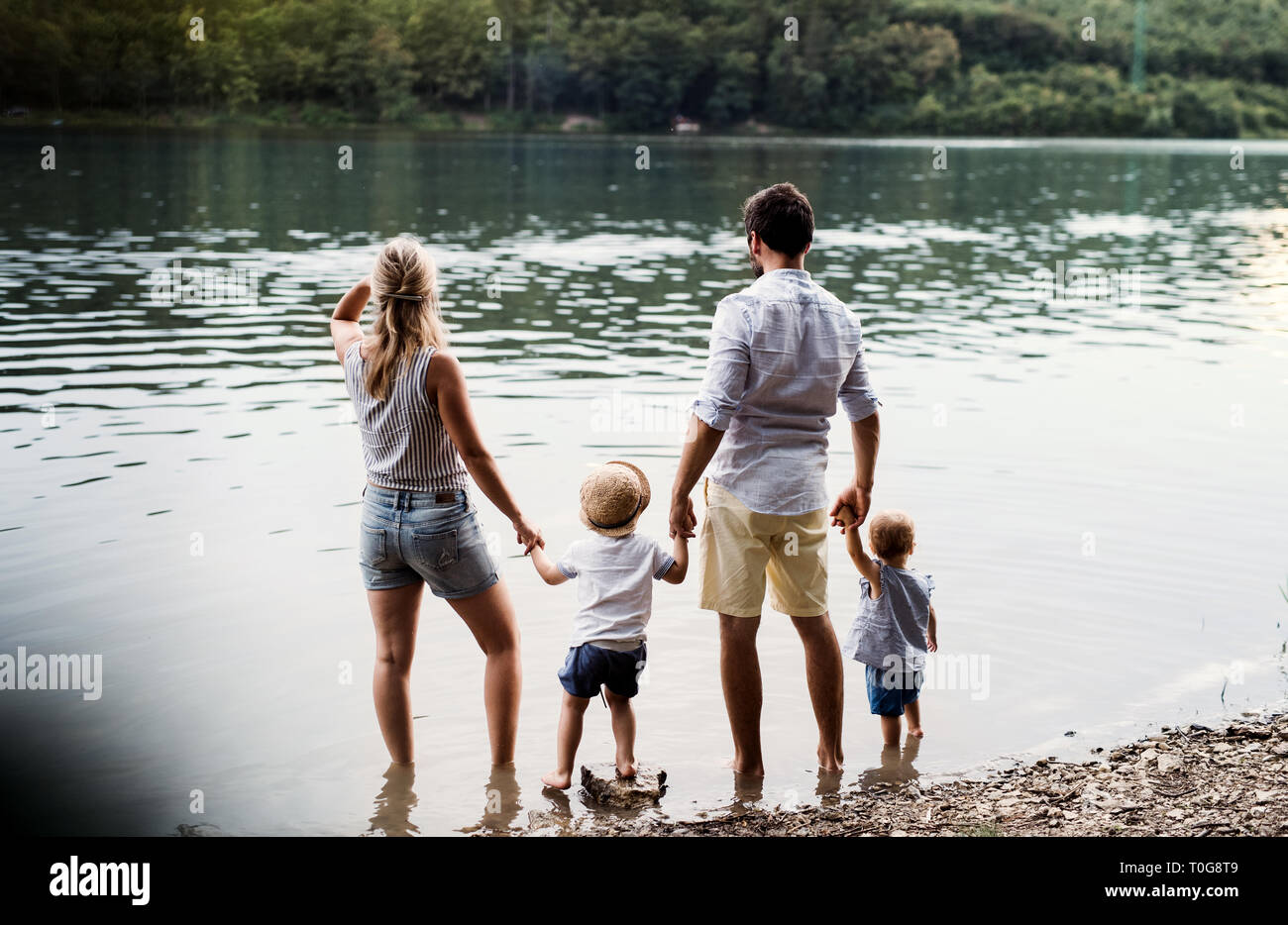 Ein junge Familie mit 2 Kleinkind Kinder die Zeit draußen am Fluss im Sommer. Stockfoto