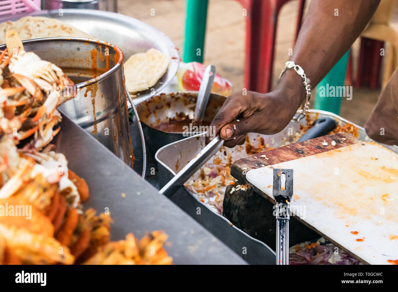 Männliche Hand ein Koch Meeresfrüchte im Freien in einem Street Market in Colombo, Sri Lanka. Stockfoto