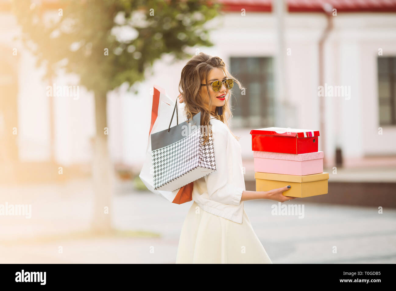 Gerne Modell in Weiß sieht und Sonnenbrille holding Einkaufstaschen u Stockfoto