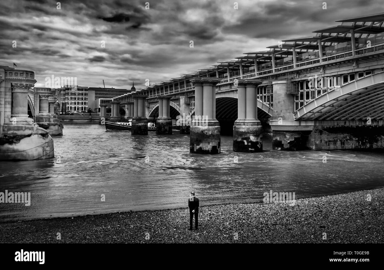 Mann am Ufer der Themse bei der Blackfriars Eisenbahnbrücke, London UK Stockfoto