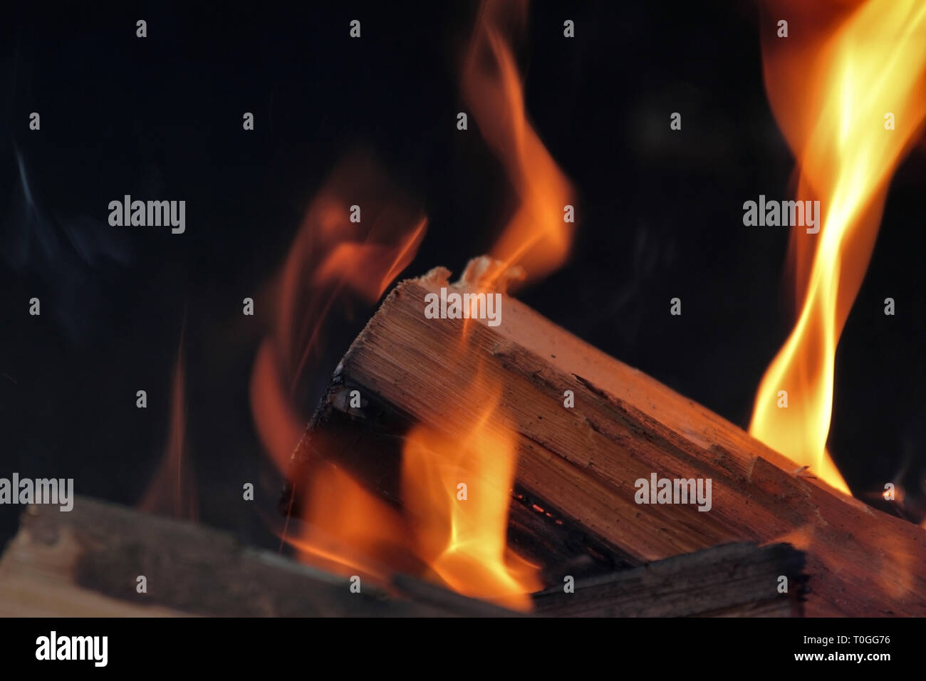 Ein Schuß von brennendem Holz in den Kamin. Close-up. Das Verbrennen von Holz zum Grillen ein. Rauch und Funken. Feuer Hintergrund. Stockfoto