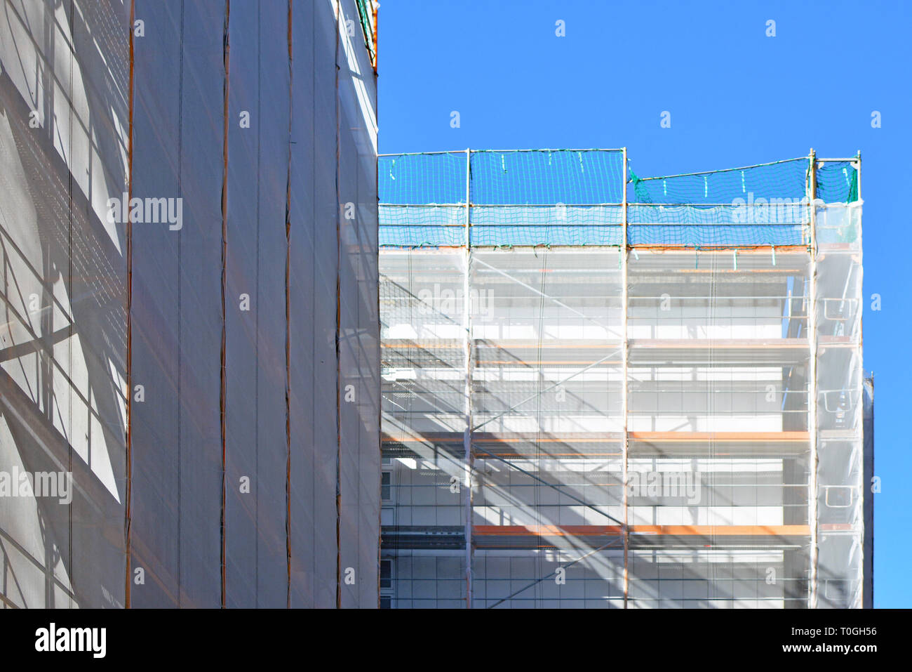 Baustelle mit Gerüst auf, mehrstöckiges Gebäude Fassade während der Sanierung Stockfoto