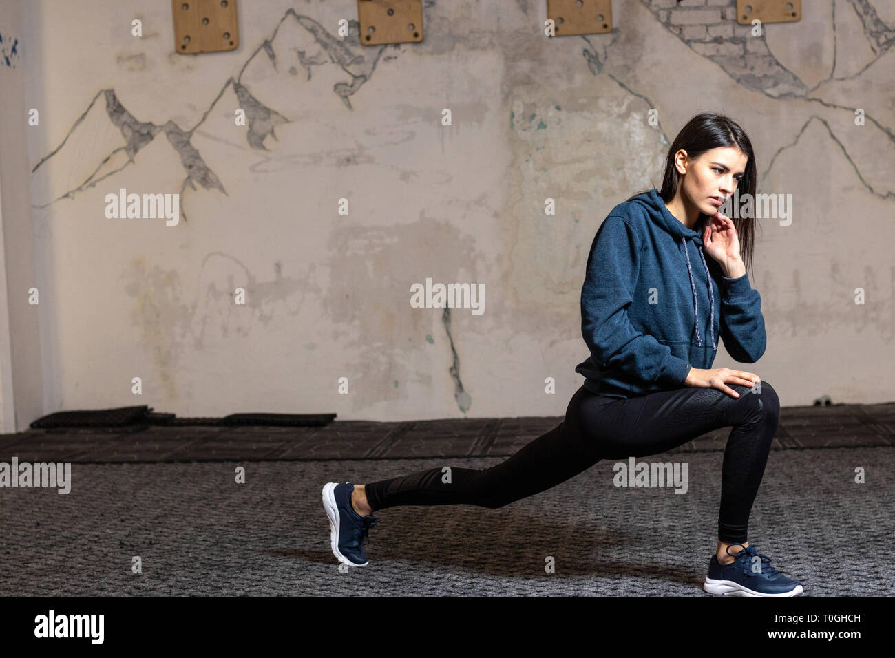 Das Mädchen trifft Stretching in der Turnhalle Stockfoto