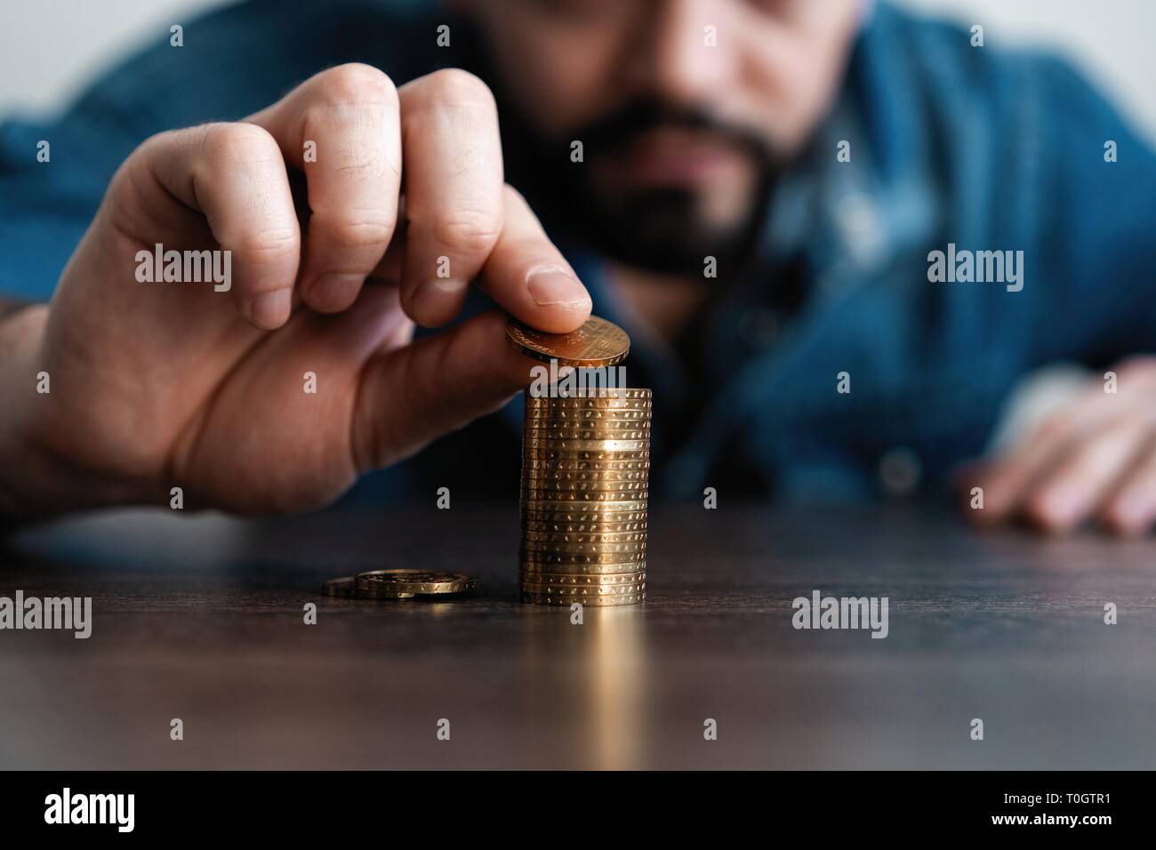 Business Mann, eine Münze auf Münzen Stapel speichern Bank und für sein Geld Konto alle in die Finanzbuchhaltung Konzept Stockfoto