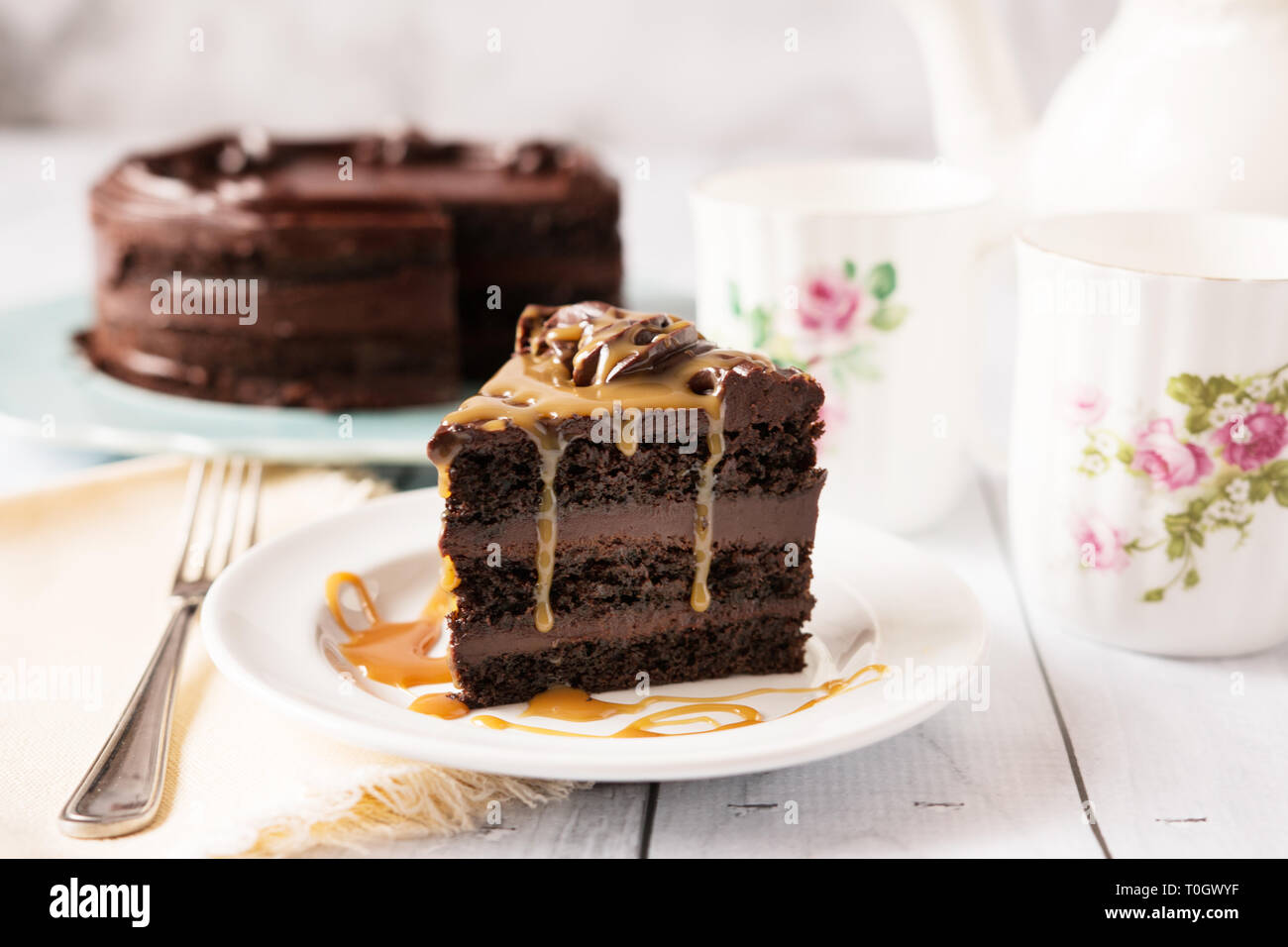 Ein Stück Chocolate Mousse Cake beträufelt mit Karamell, in einem hübschen Tee Tabelle einstellen. Stockfoto