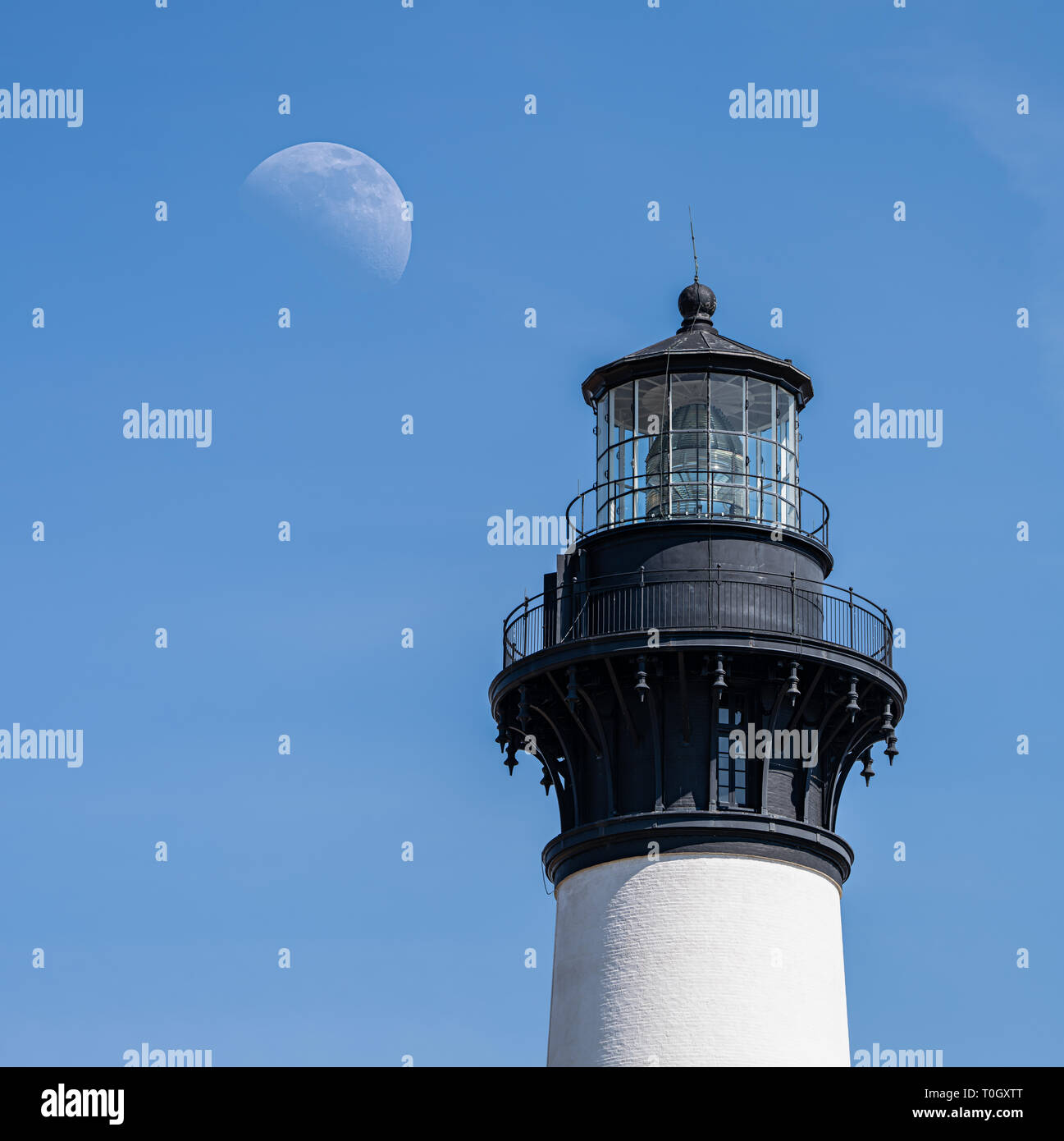 Das obere Licht eines Leuchtturmes auf den Outer Banks von North Carolina neben einem halben Mond Stockfoto