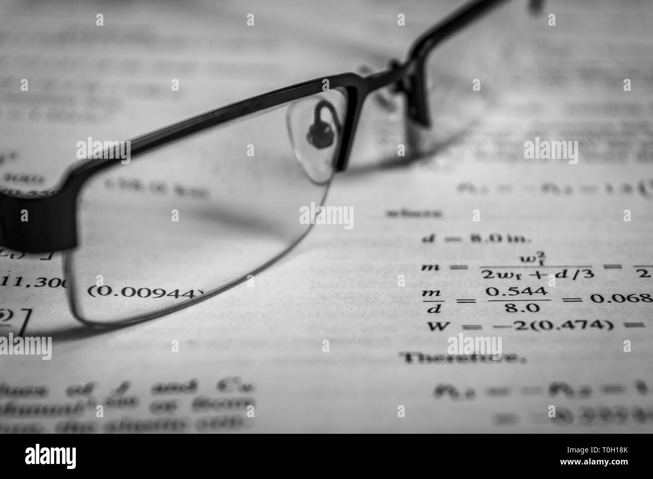 Brillen gehalten auf ein Buch nach dem Lesen Stockfoto