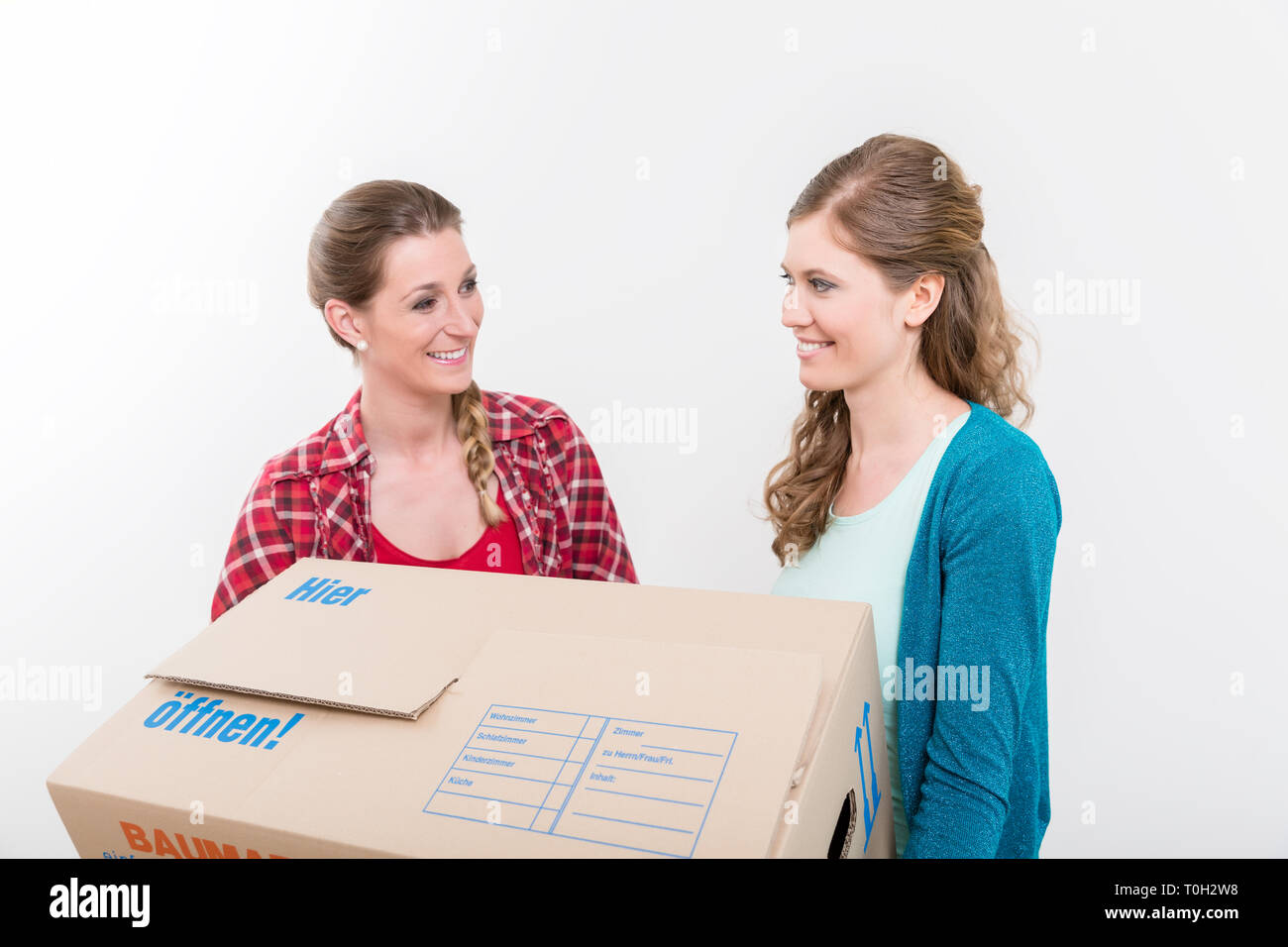 Lächelnde Frauen, die den Karton Stockfoto