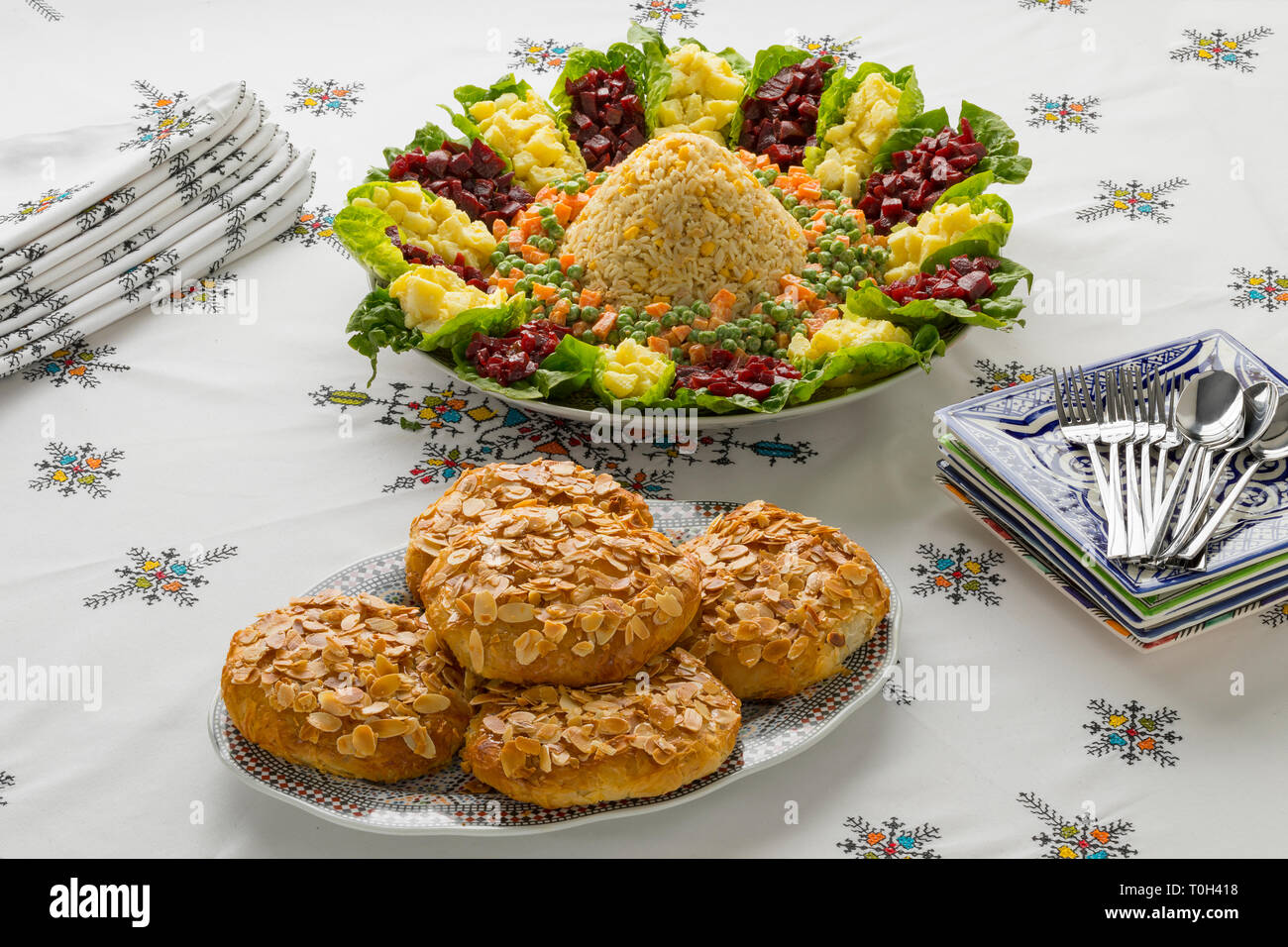 Schale mit traditionellen festlichen Marokkanischen gemischter Salat und Mini bastella auf einem schön gedeckten Tisch Stockfoto