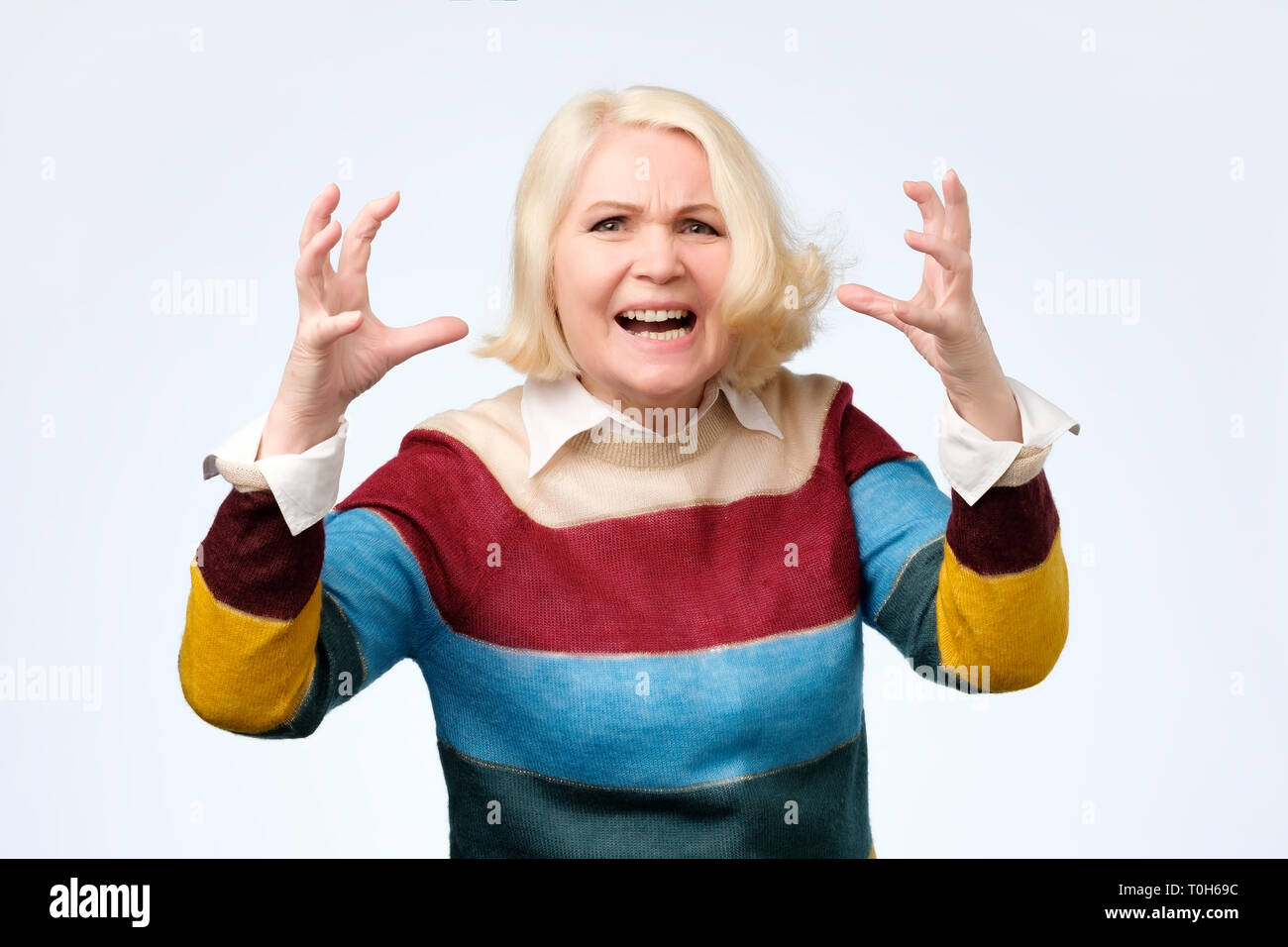 Böse alte Frau, die verärgert Gesichtsbehandlung Geste auf weißem Hintergrund Stockfoto