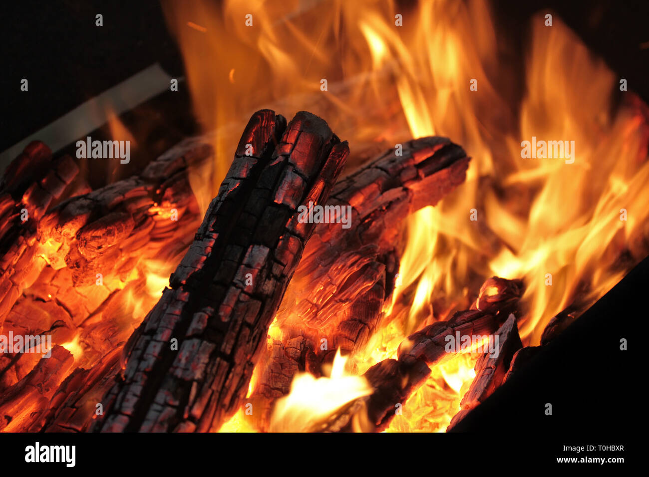 Ein Schuß von brennendem Holz in den Kamin. Close-up. Das Verbrennen von Holz zum Grillen ein. Rauch und Funken. Feuer Hintergrund. Stockfoto