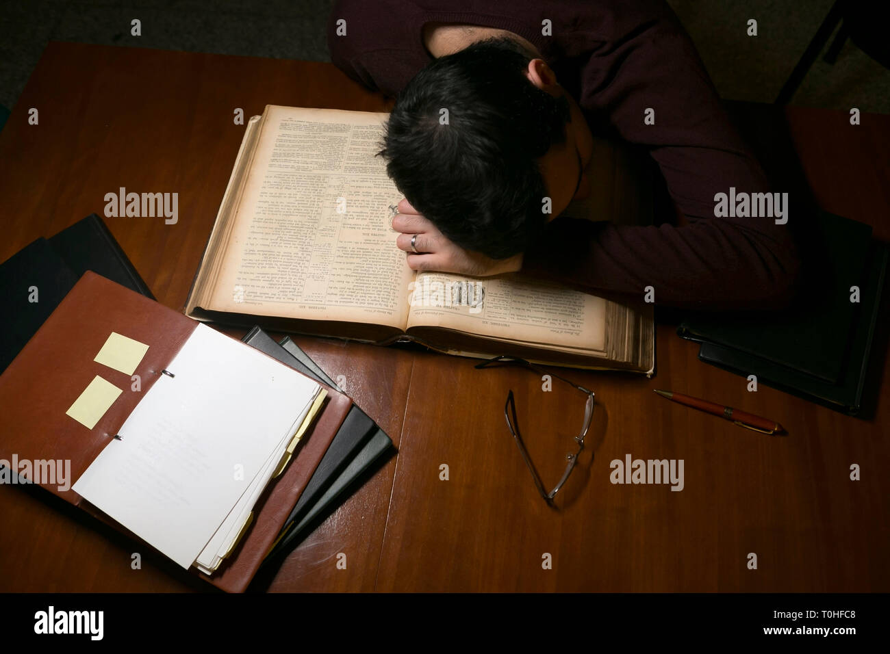 Mann nach dem Lesen ein altes Buch müde Stockfoto