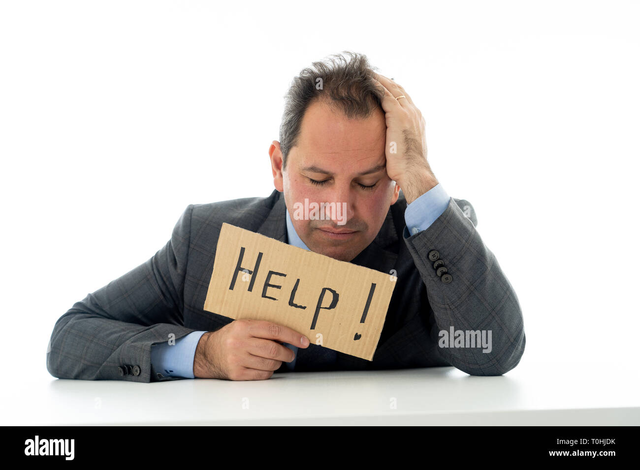 Deprimiert kaukasischen Geschäftsmann mittleren Alters verzweifelten und müde Holding eine Hilfe Zeichen suchen, frustriert, traurig und unglücklich. Im Geschäft und Stress bei der w Stockfoto