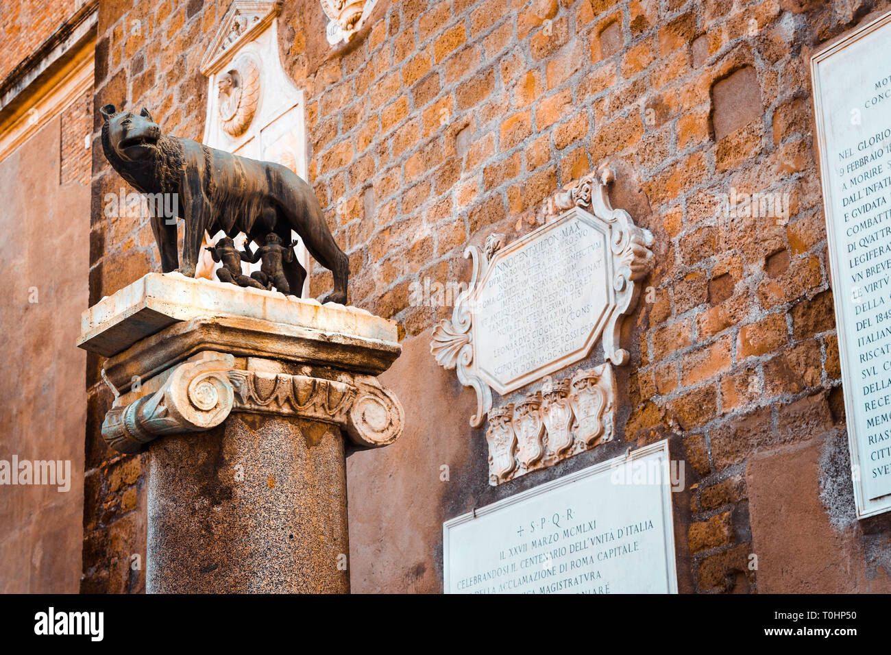 In der Nähe der Statue des Kapitolinischen Wolf mit Romulus und Remus, Symbol der Stadt Rom, die auf einem alten Marmor und Stein Spalte und mit den Ländern Lateinamerikas Stockfoto