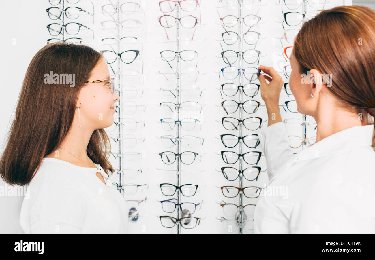Girl shopping für Gläser an den Optiker mit Doktor Stockfoto