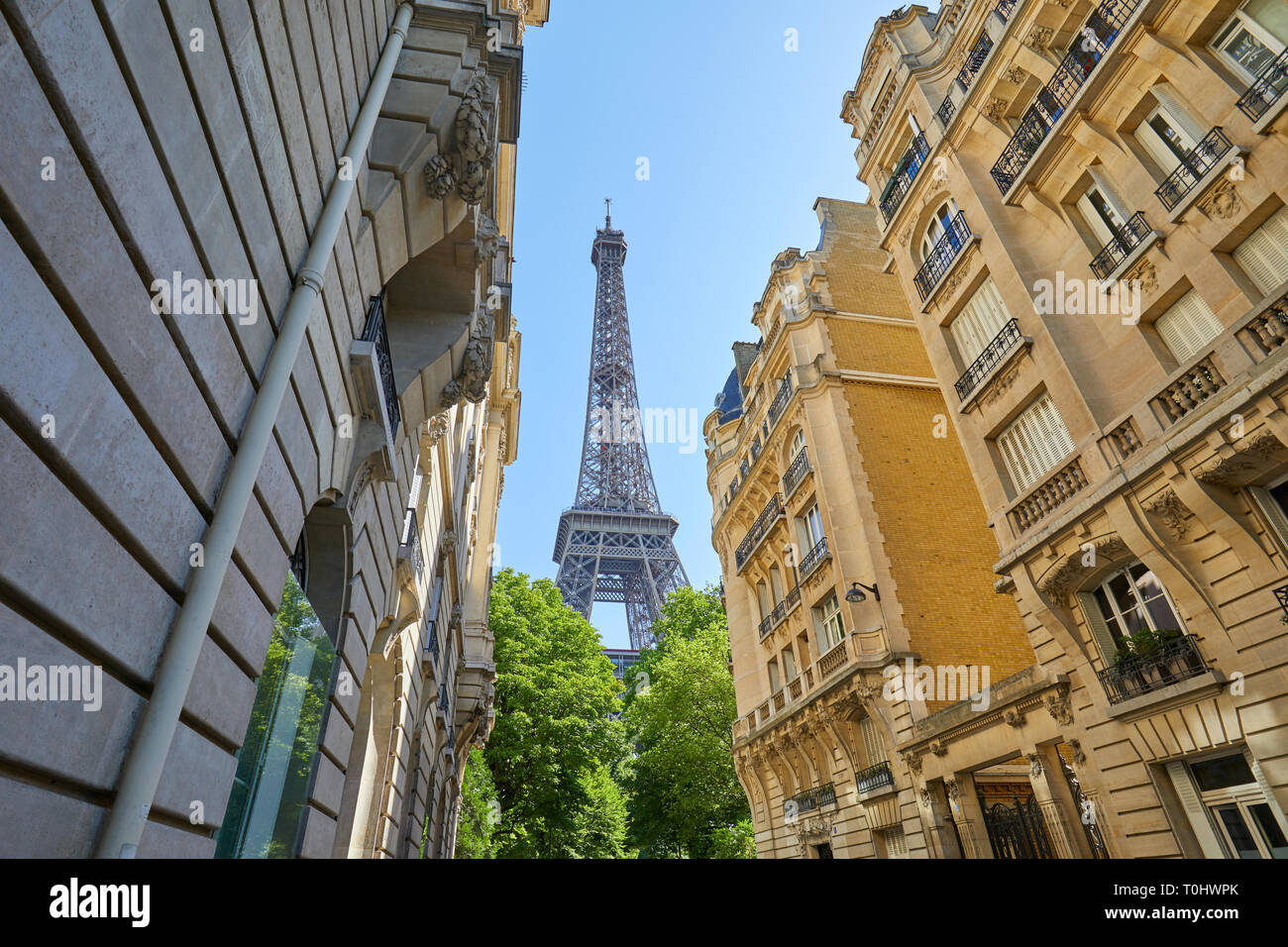PARIS, Frankreich, 21. JULI 2017: Eiffelturm und typische Straße mit alten Gebäuden in Paris an einem sonnigen Sommertag, Clear blue sky Stockfoto