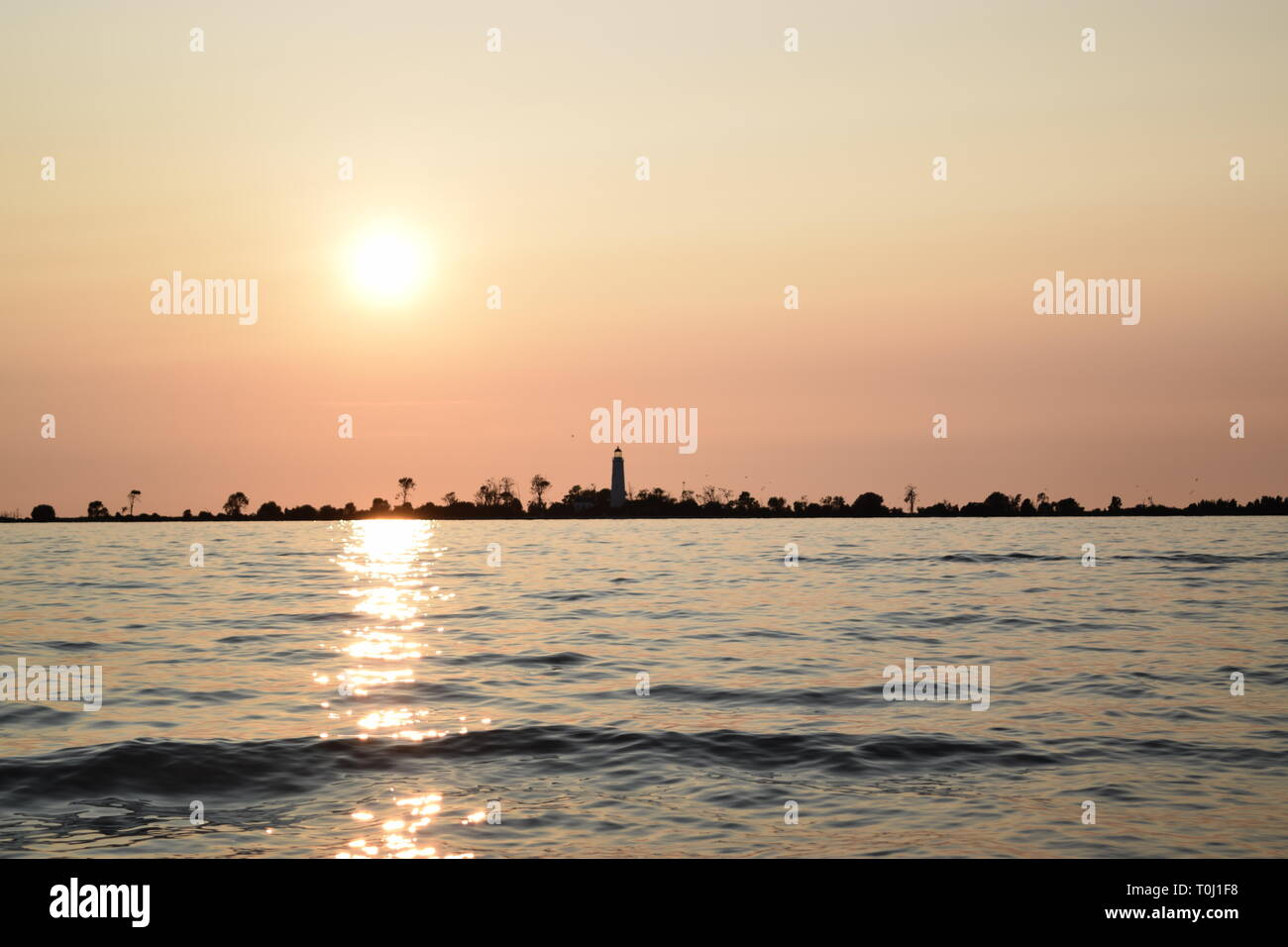 Strand Sonnenuntergang mit Leuchtturm und klares Wasser. Glatte Ruhig, Sommerabend, Ontario, Kanada. Stockfoto