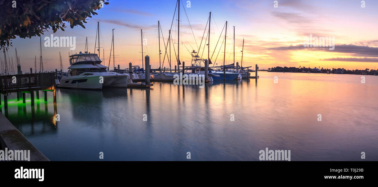 Tagesanbruch Sonnenaufgang über Yachten und Segelboote im Werk Bay Marina in Marco Island, Florida Stockfoto