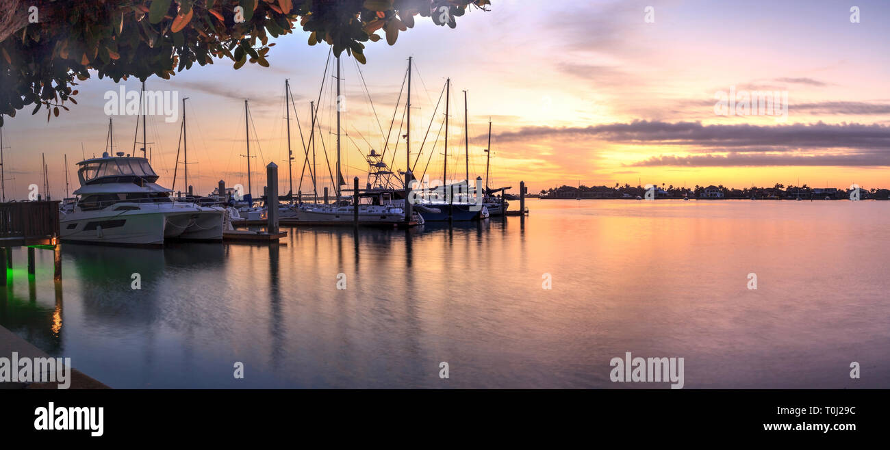 Tagesanbruch Sonnenaufgang über Yachten und Segelboote im Werk Bay Marina in Marco Island, Florida Stockfoto