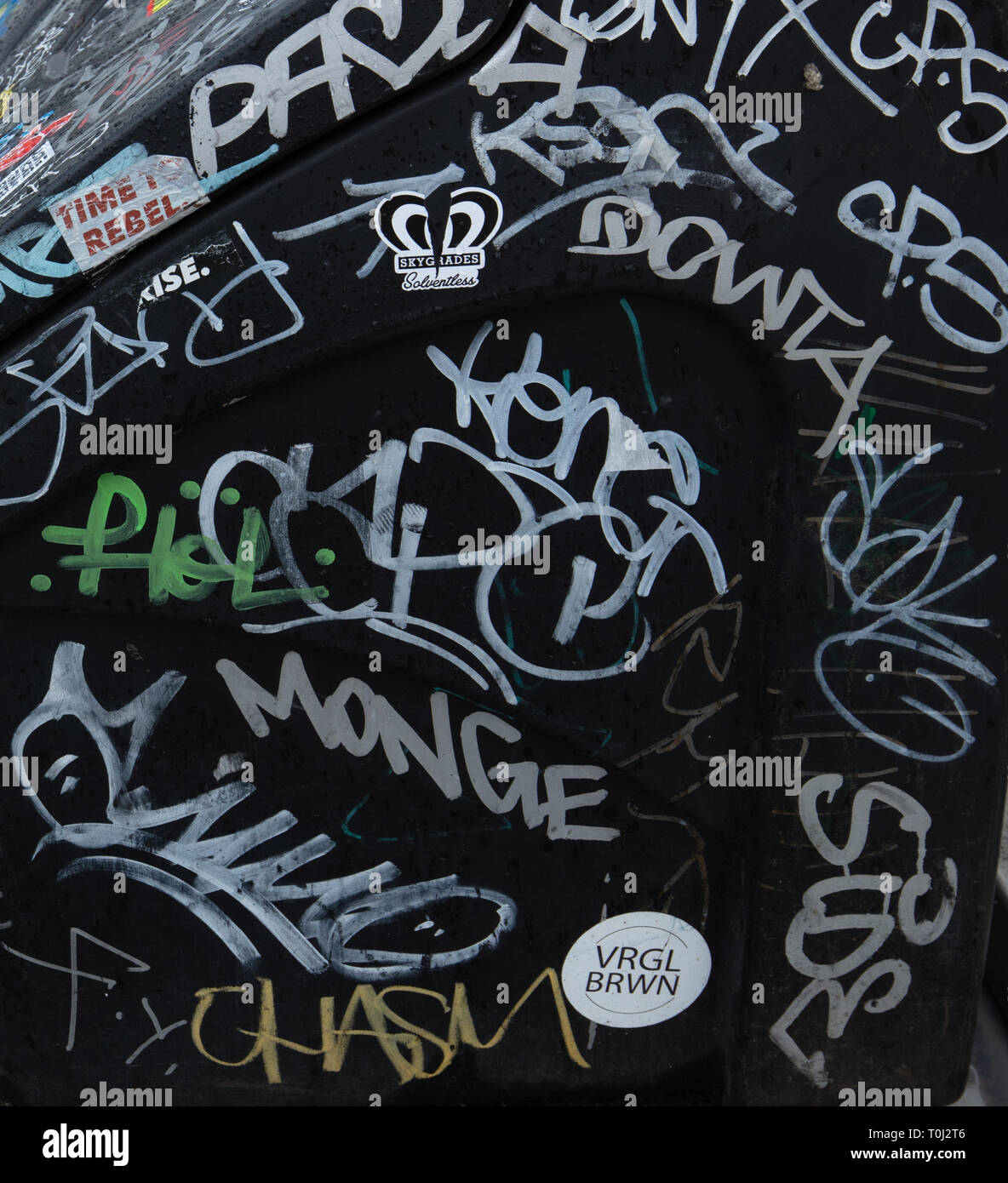 Menschen zeichnen Graffiti Buchstaben und scribble in zufälliger Weise auf der Oberfläche eines schwarzen Kasten auf der Golden Jubilee Bridge, South Bank, London, UK. Stockfoto