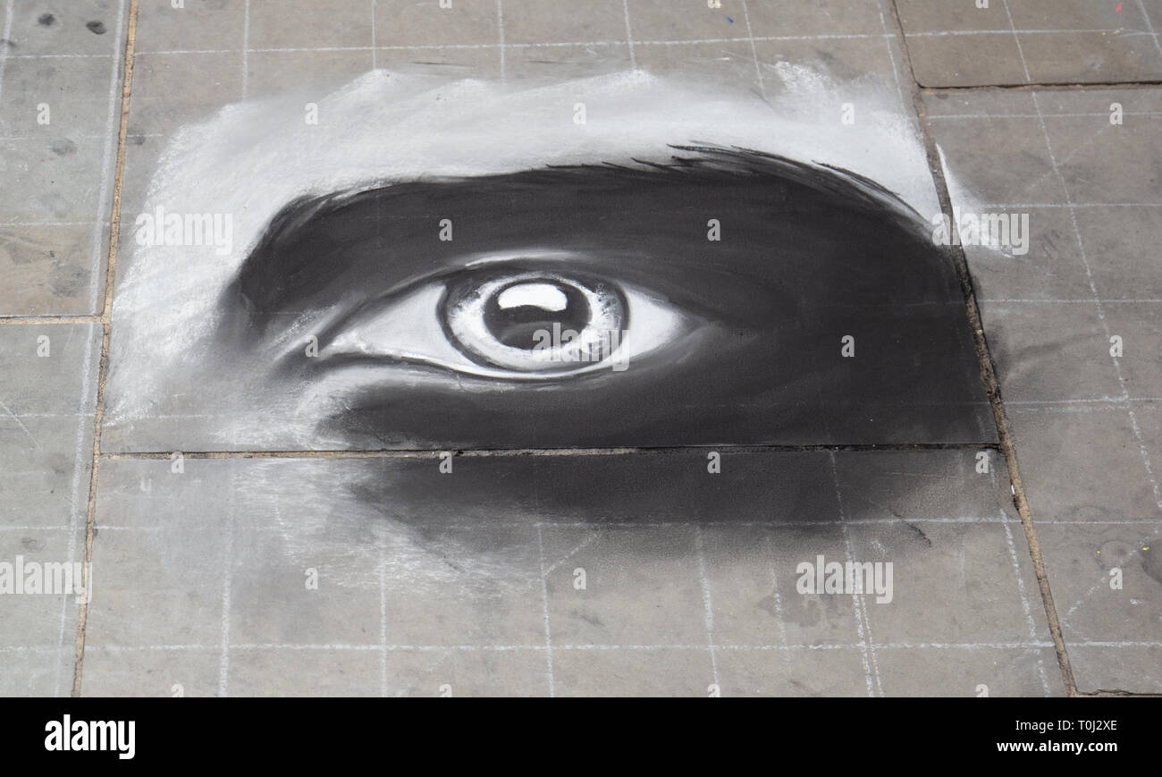 Street artist zeichnet ein Auge auf die Pflasterung von Piccadilly Circus London, UK zu unterhalten und Spenden von Touristen und andere Besucher empfangen. Stockfoto