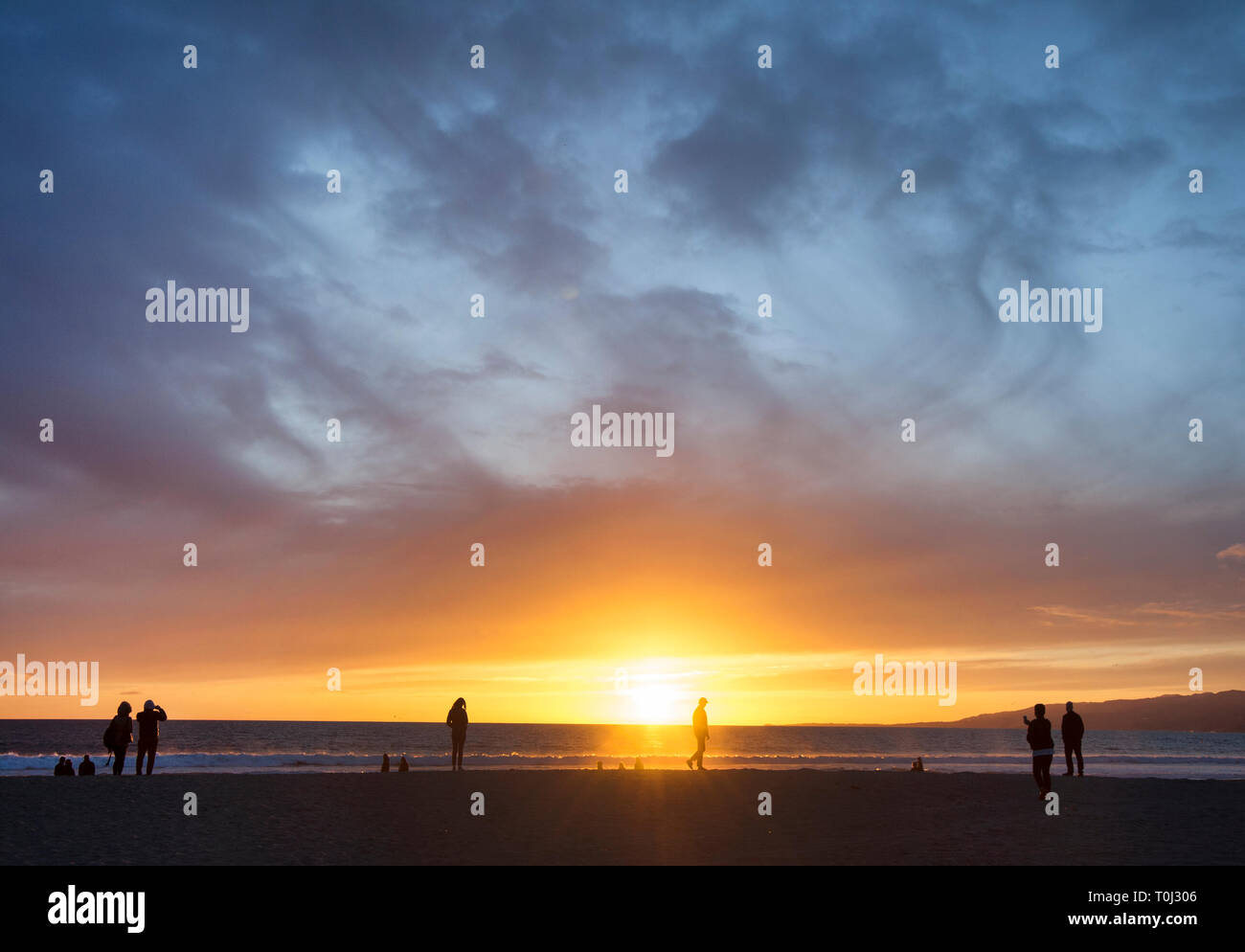 Die Leute am Strand bei Sonnenuntergang in Santa Monica, CA Stockfoto