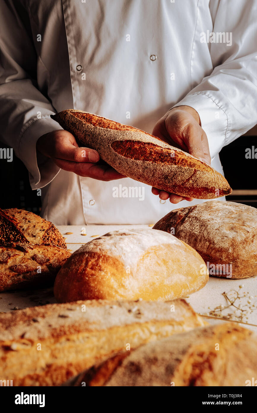Baker Gefühl zufrieden, nachdem Sie schöne Brotsorten erfolgreich Stockfoto