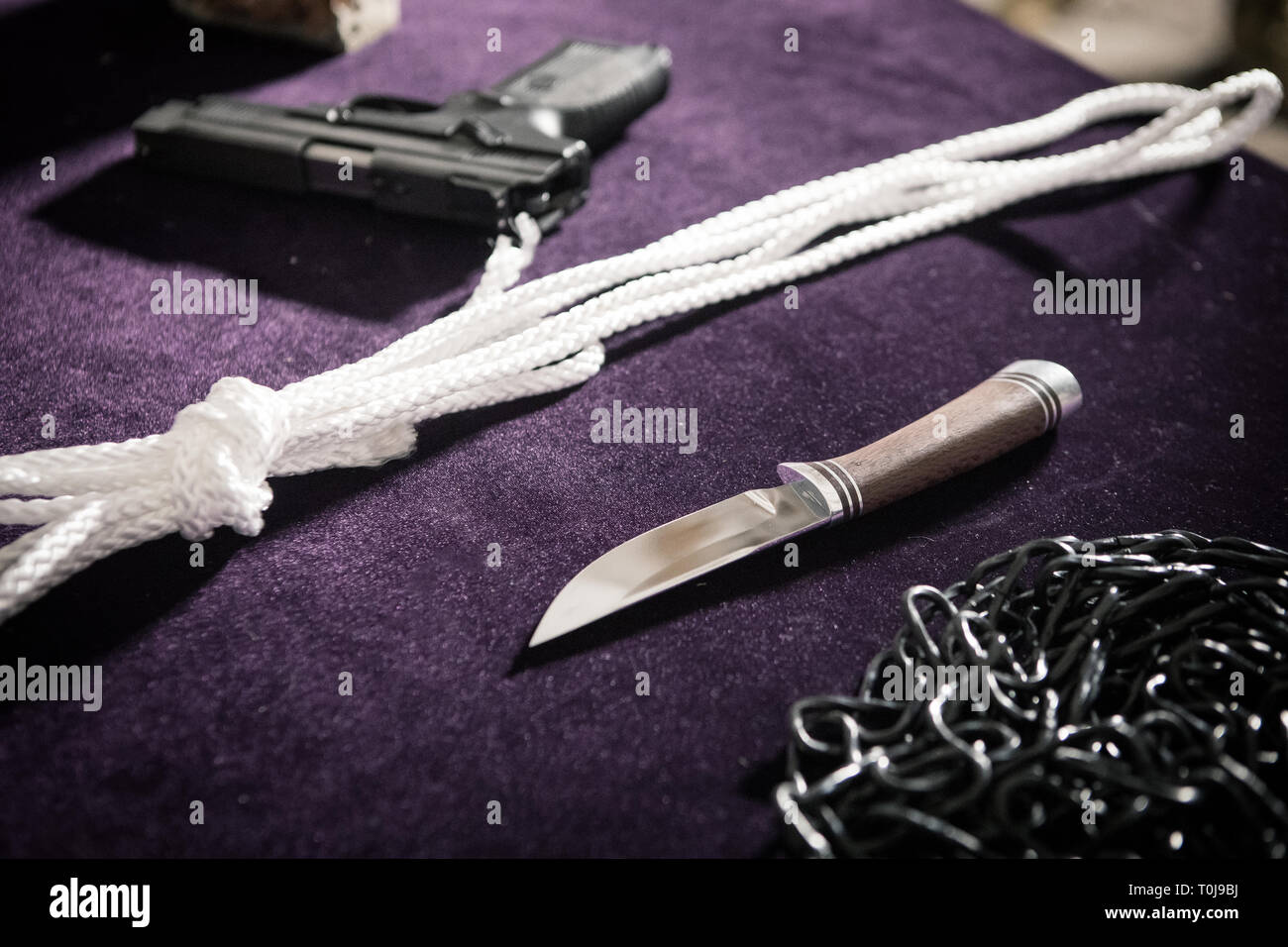 Pistole, Messer, Seil, Kette, Gun am Tatort auf dem Tisch, Kriminalität Berichte, Foto bei hohen ISO-Werten Stockfoto