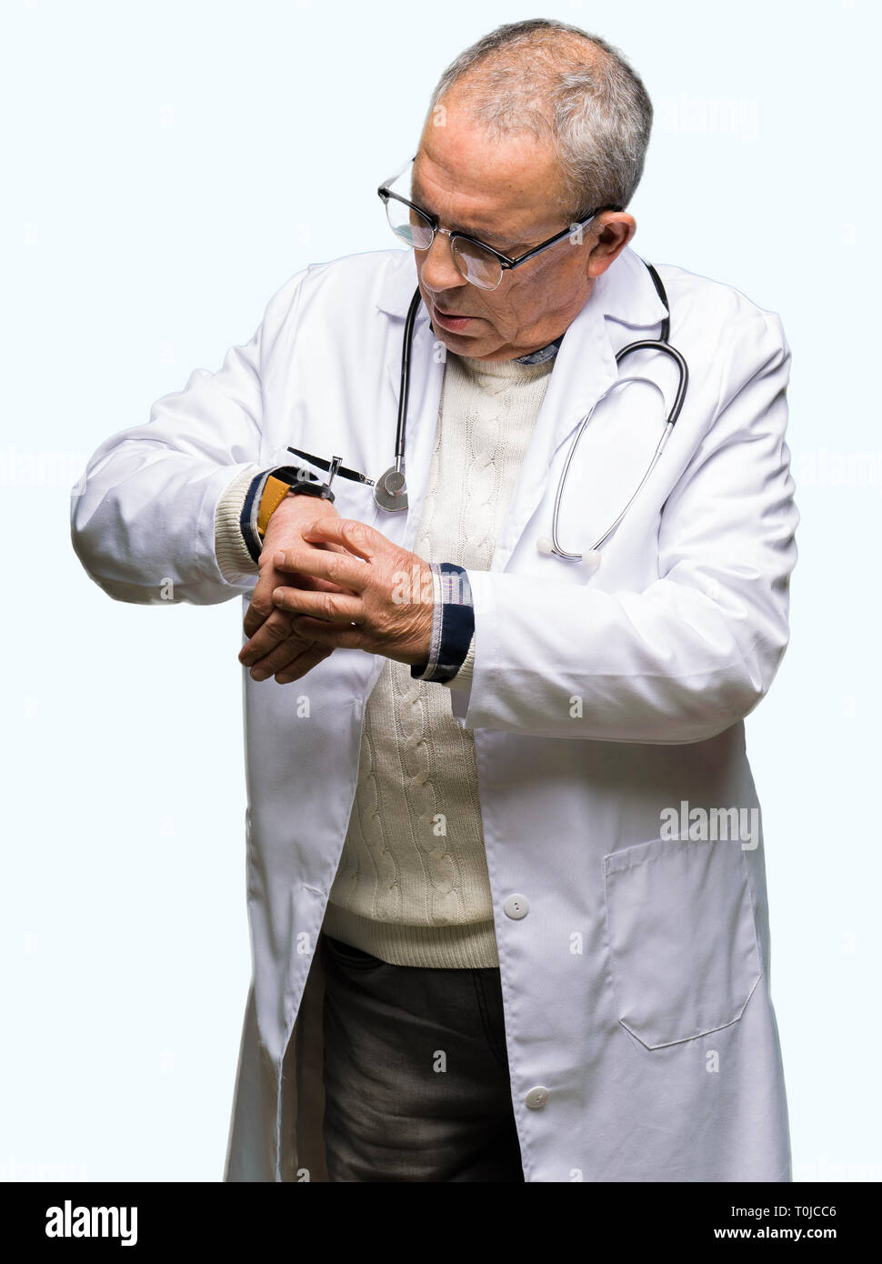 Stattliche leitender Arzt Mann, medizinische Fell Kontrolle der Zeit auf Armbanduhr, entspannt und zuversichtlich Stockfoto