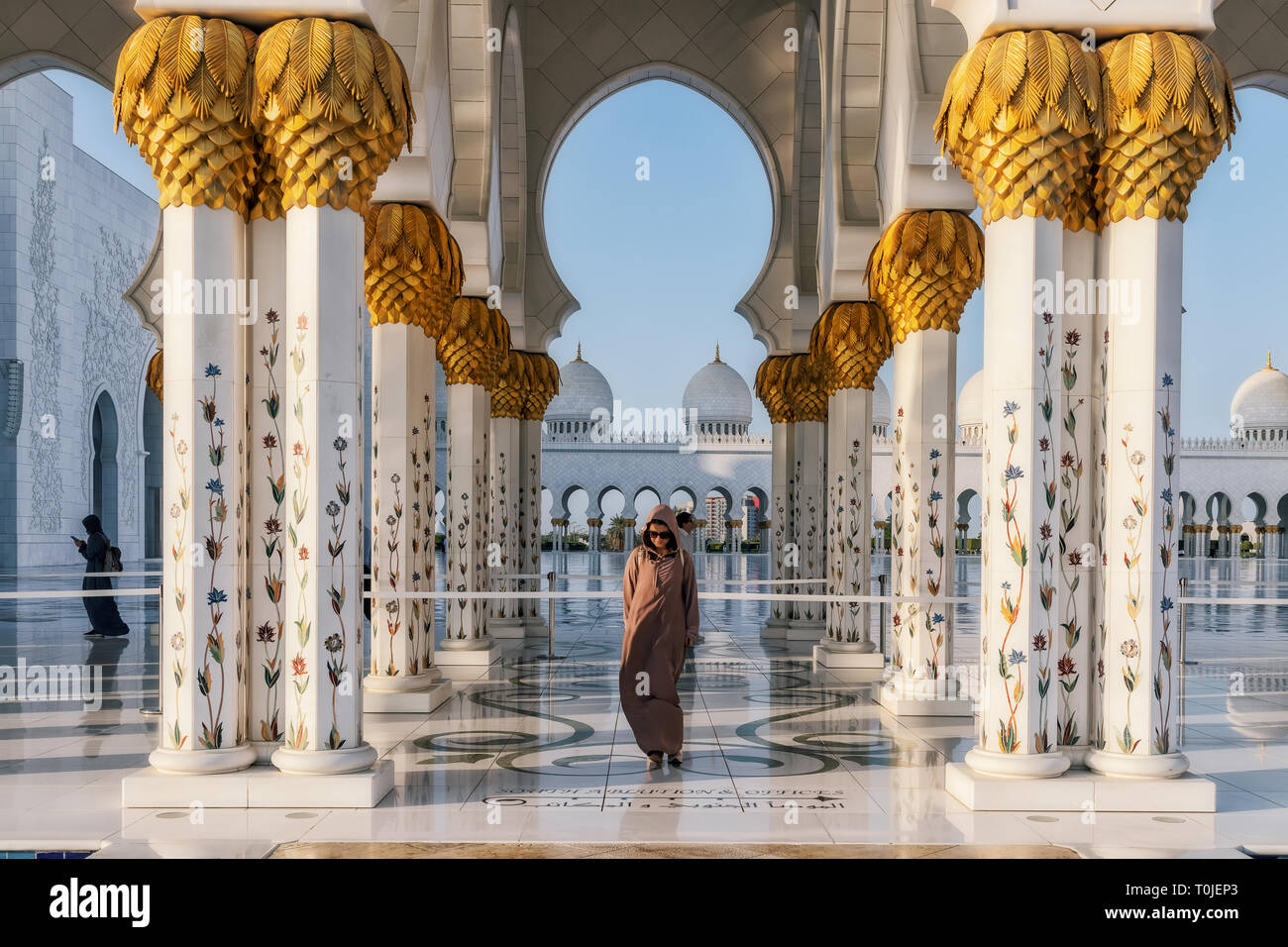UAE/ABUDHABI 15 DEZ 2018 - Frau, die auf der Fassade der arabischen Moschee. Stockfoto