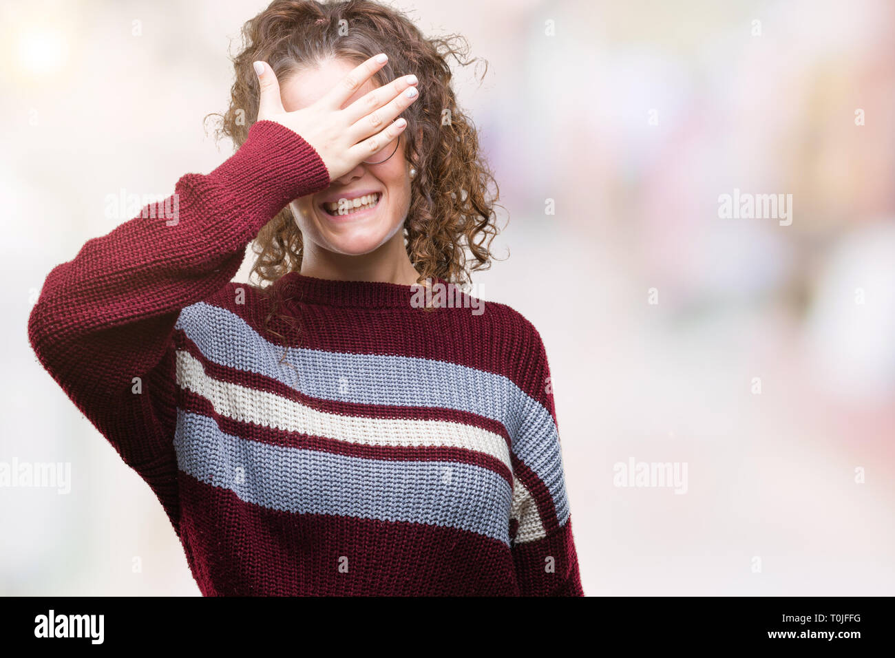 Schöne Brünette lockige Haare junge Mädchen Tragen einer Brille über isolierte Hintergrund Lächeln und Lachen mit der Hand auf das Gesicht, die Augen für Überraschung. B Stockfoto