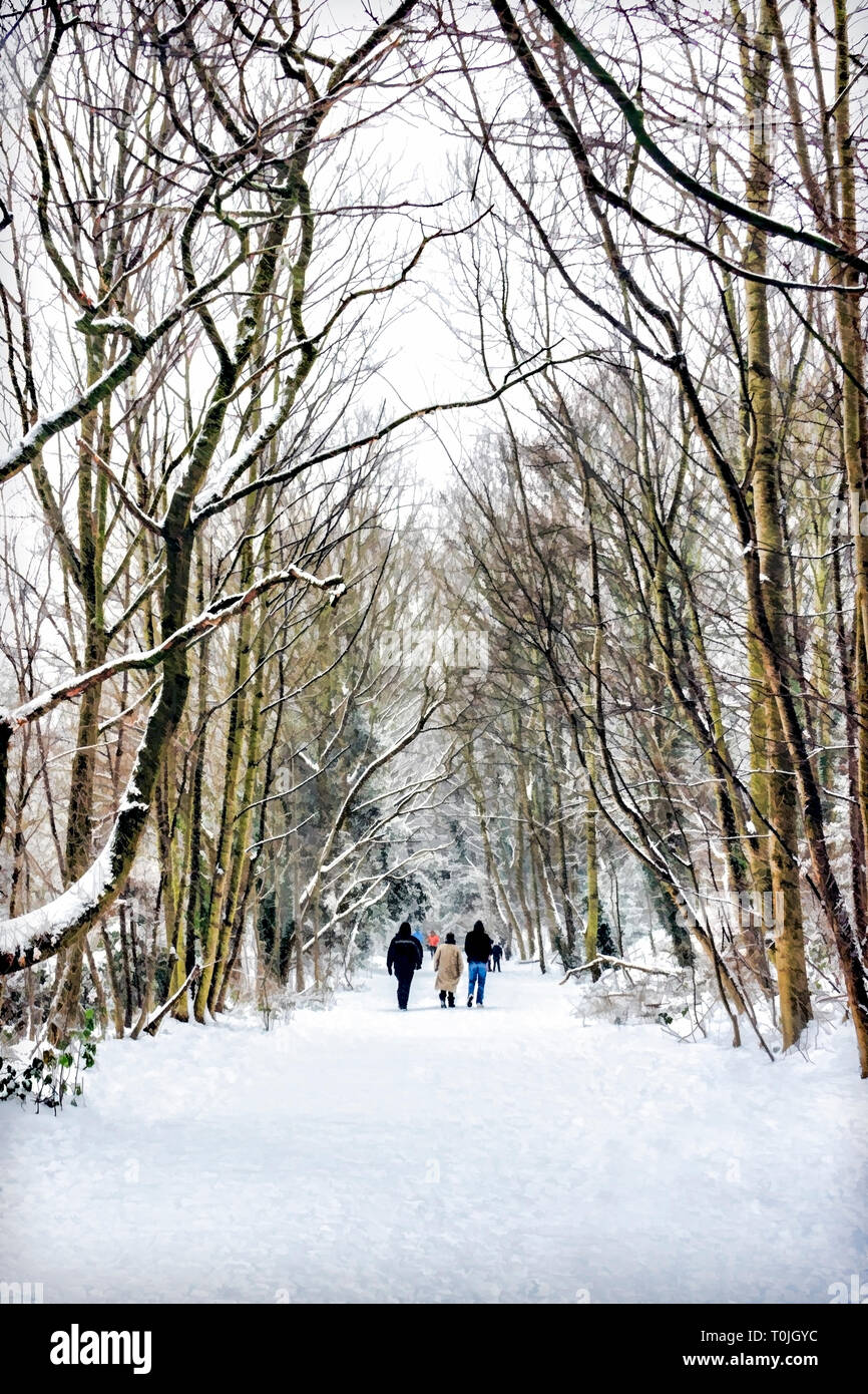 Winterszene von Leuten, die im Schnee auf dem Parkland Walk, einer stillgedeckten Eisenbahnlinie in Nord-London, spazieren, geeignet für eine Weihnachts- oder Grußkarte Stockfoto