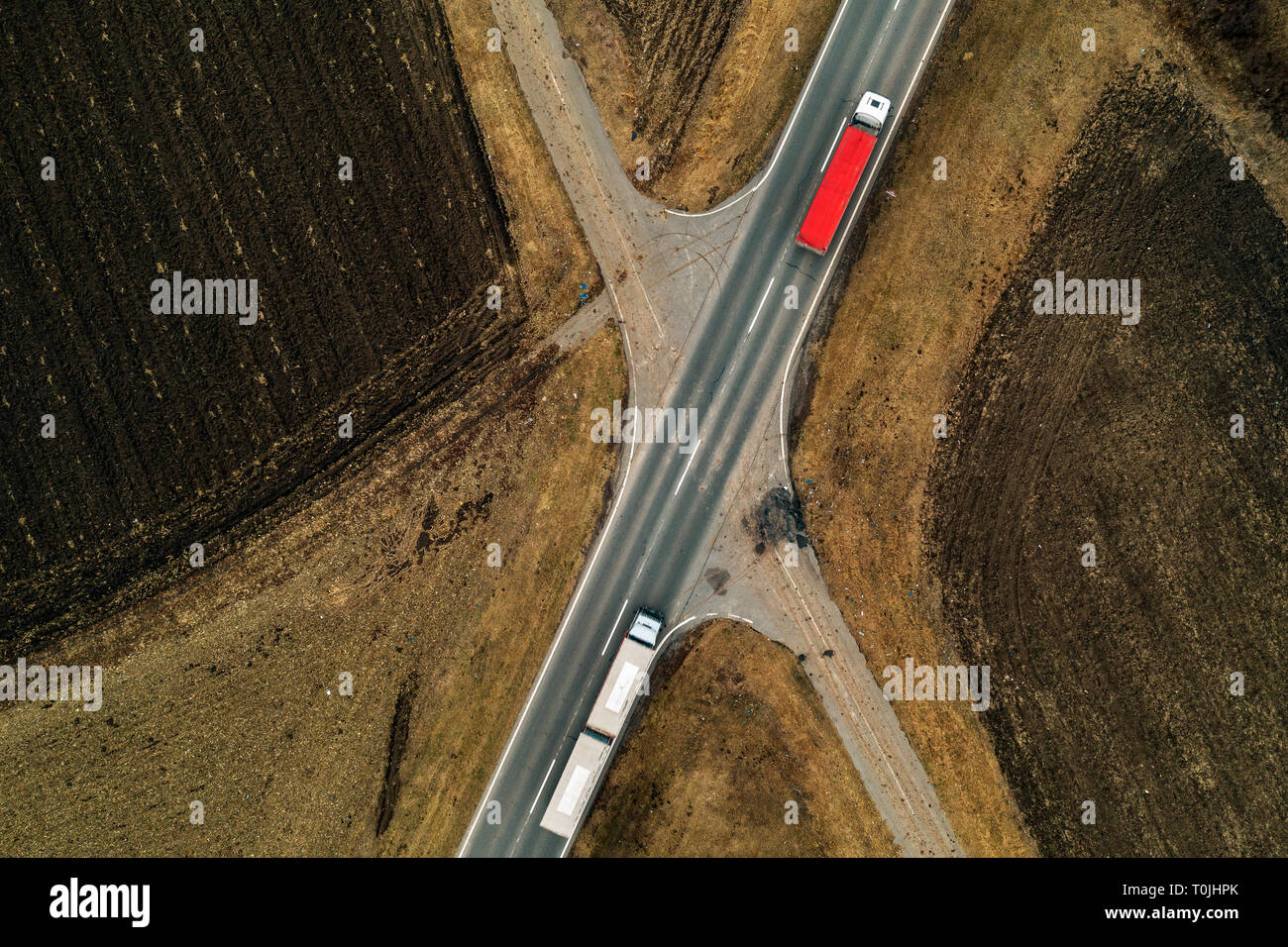 Lkw auf der Straße, Luftaufnahme von Fracht Transporter auf gerader Fahrbahn durch die ebene Landschaft Landschaft von Drone pov Stockfoto